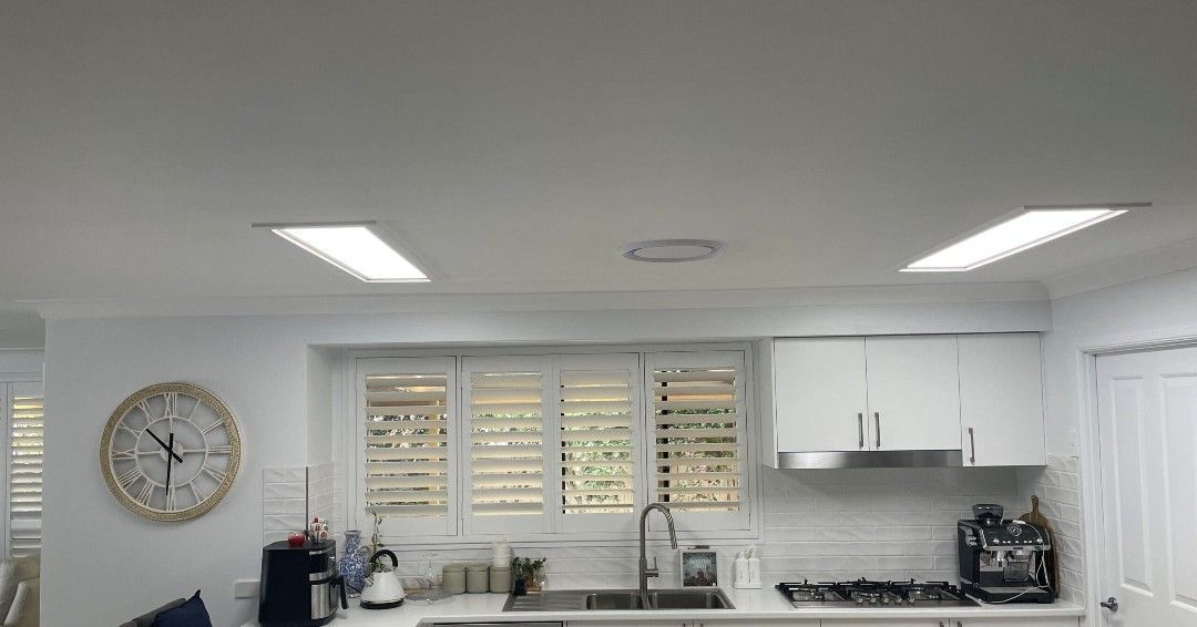 Bright white interior with open skylights, blue sky visible. Decorative wall covering and curtain in the room.