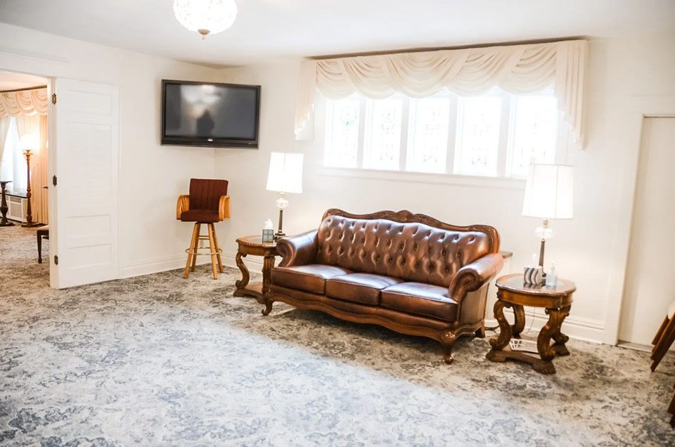 A living room with a couch , tables , and a television.