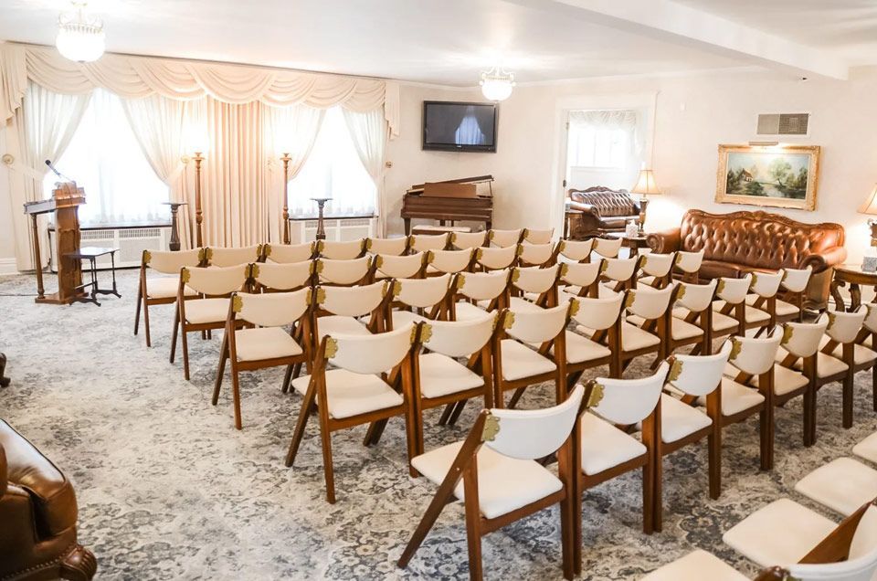 A room with rows of chairs and a piano in it.