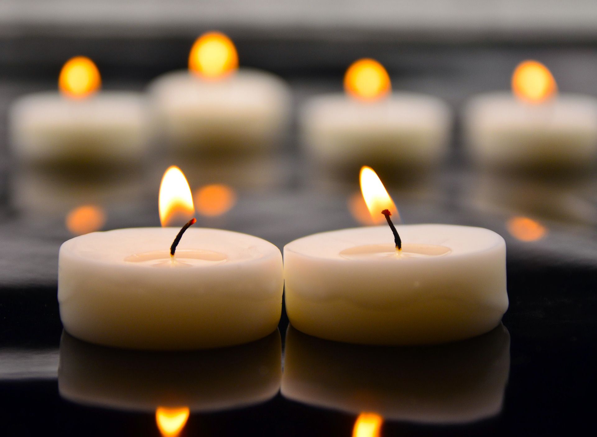 Two candles are sitting next to each other in the water.