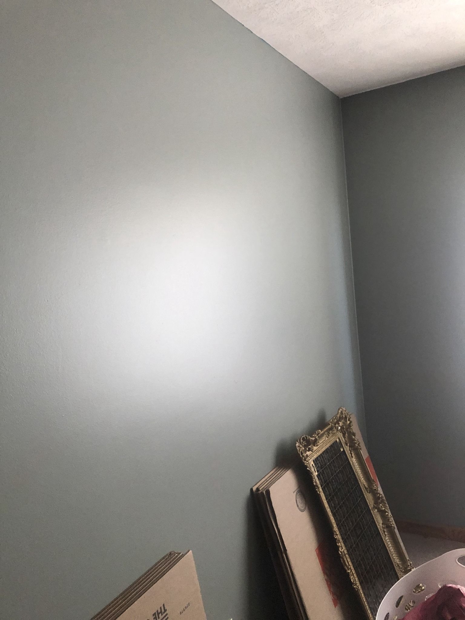 A room with a lot of boxes on the floor and a white wall.