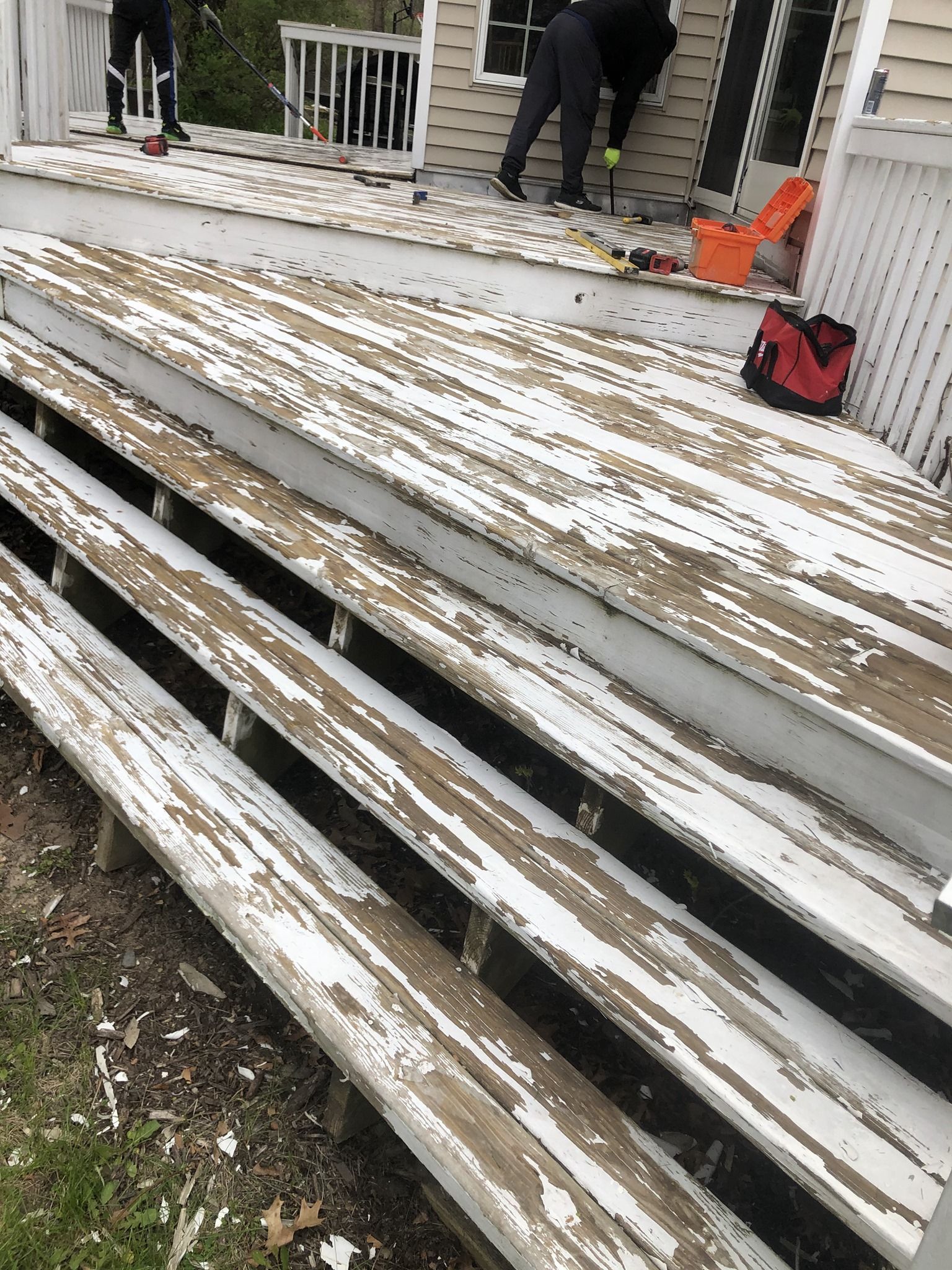A wooden deck is being painted white.