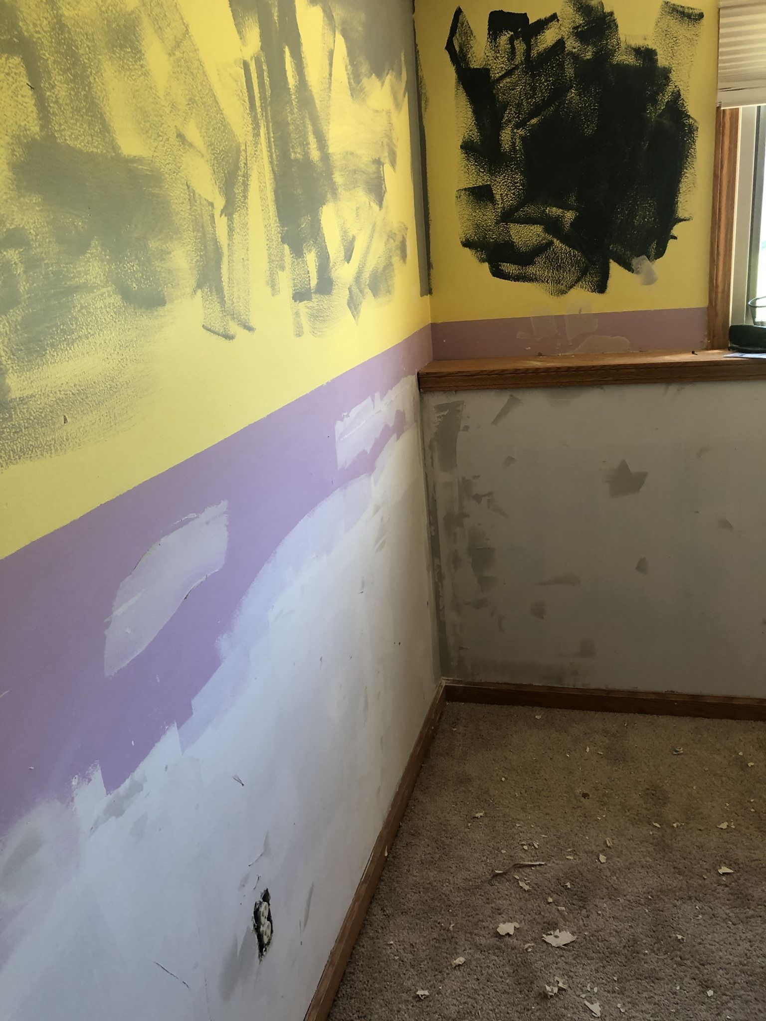 A room with a yellow and purple wall and a window.