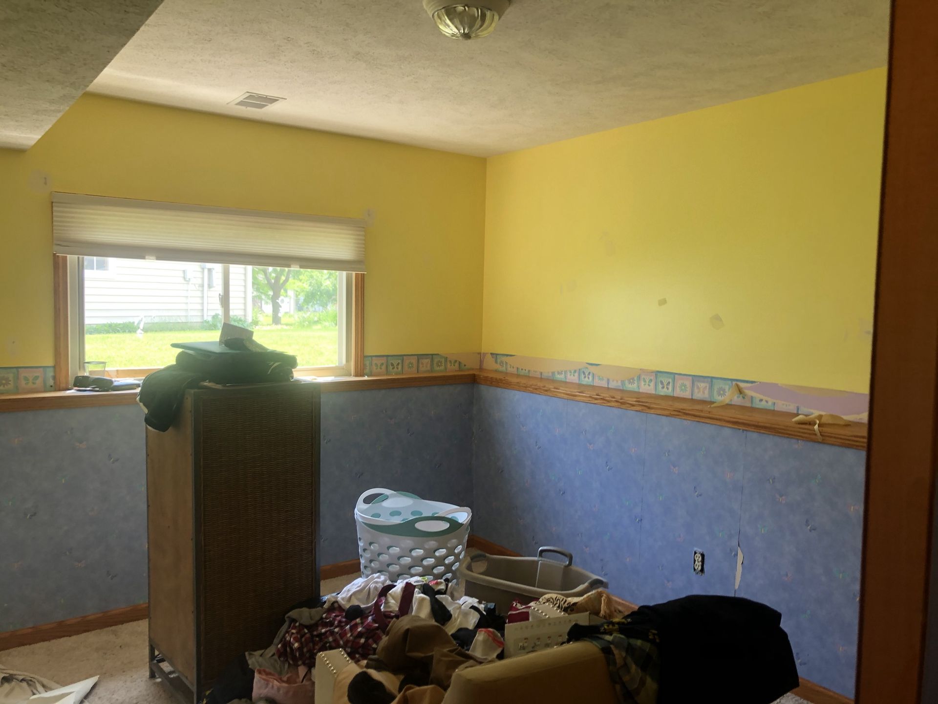 A room with yellow and blue walls and a window