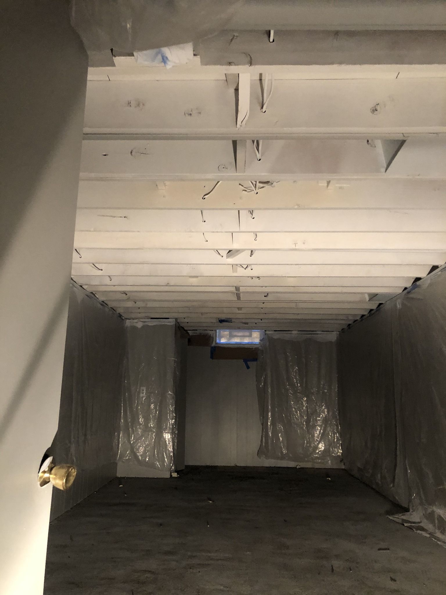 An empty room with a white ceiling and a door