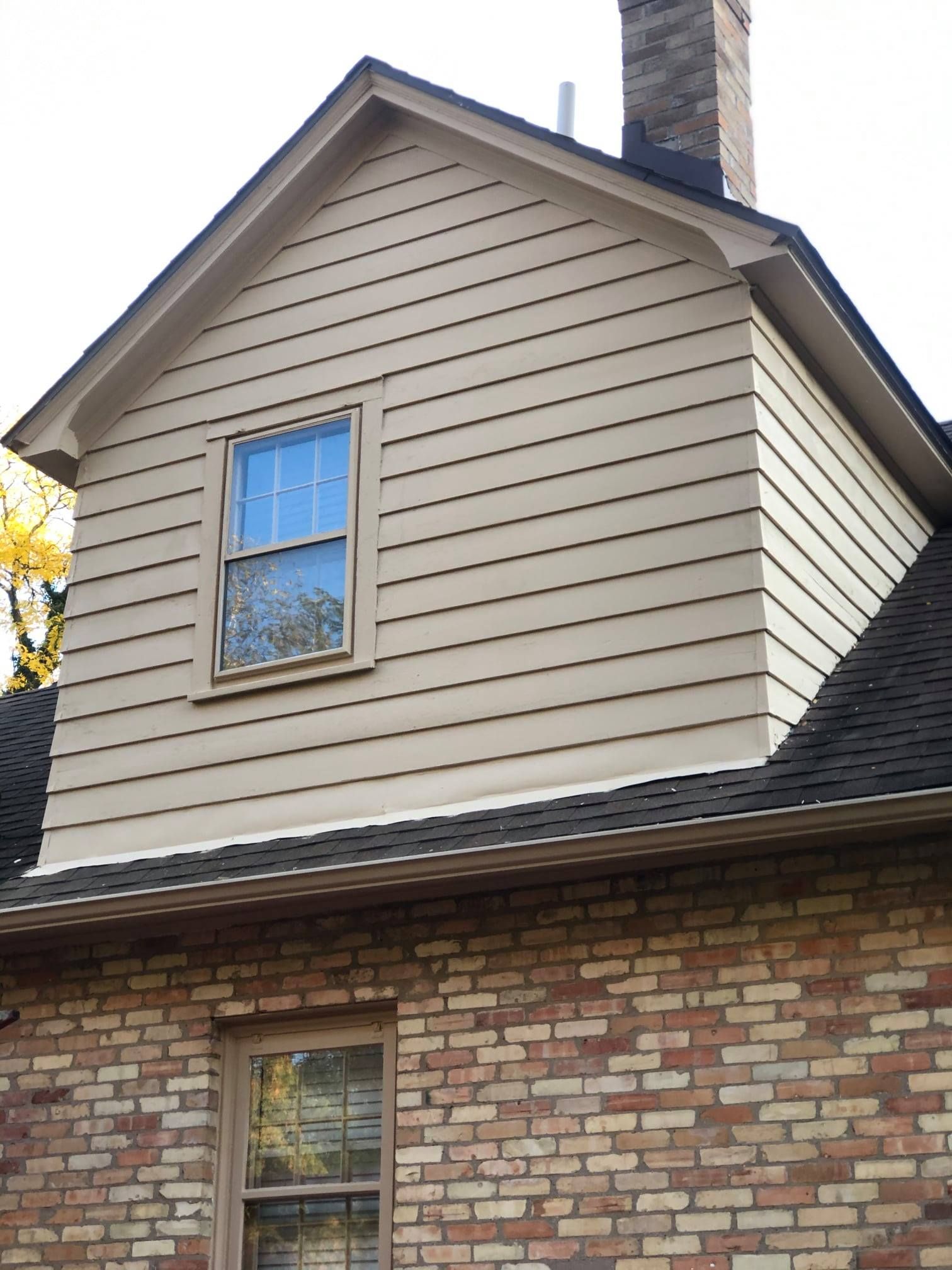 A house with a chimney and a window on the side
