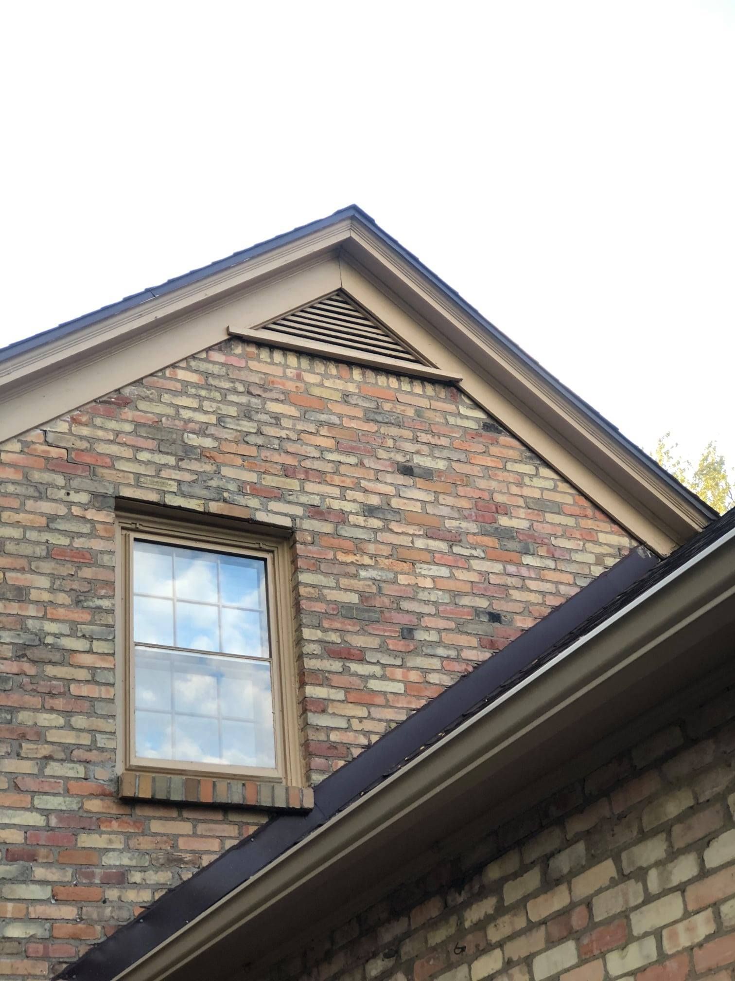 A brick house with a window and a roof
