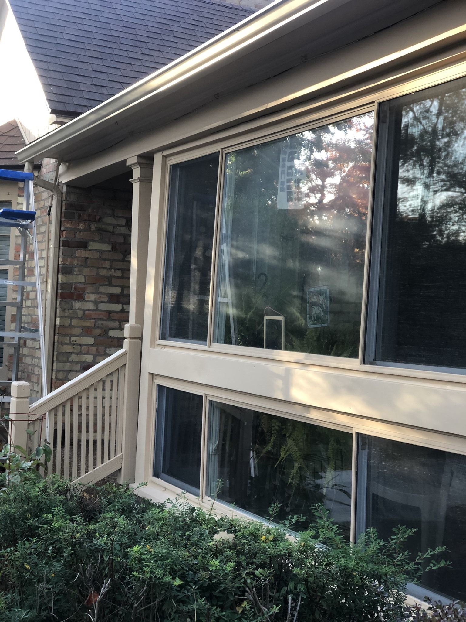 A house with a ladder on the side of it and a lot of windows.