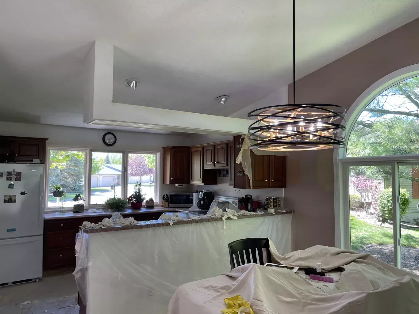 A kitchen with a table and chairs and a chandelier hanging from the ceiling.
