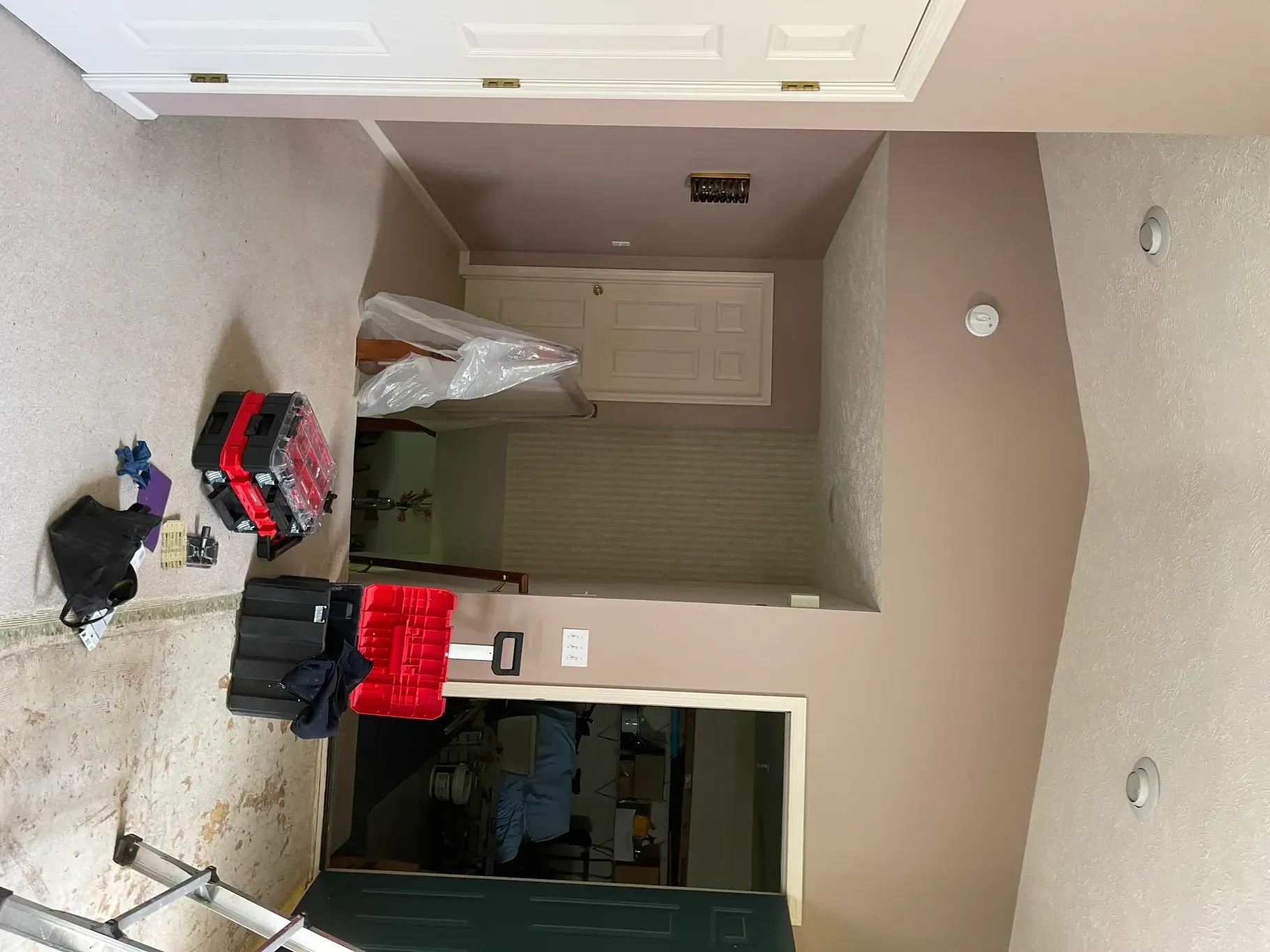 A room with a ladder and a toolbox in it.