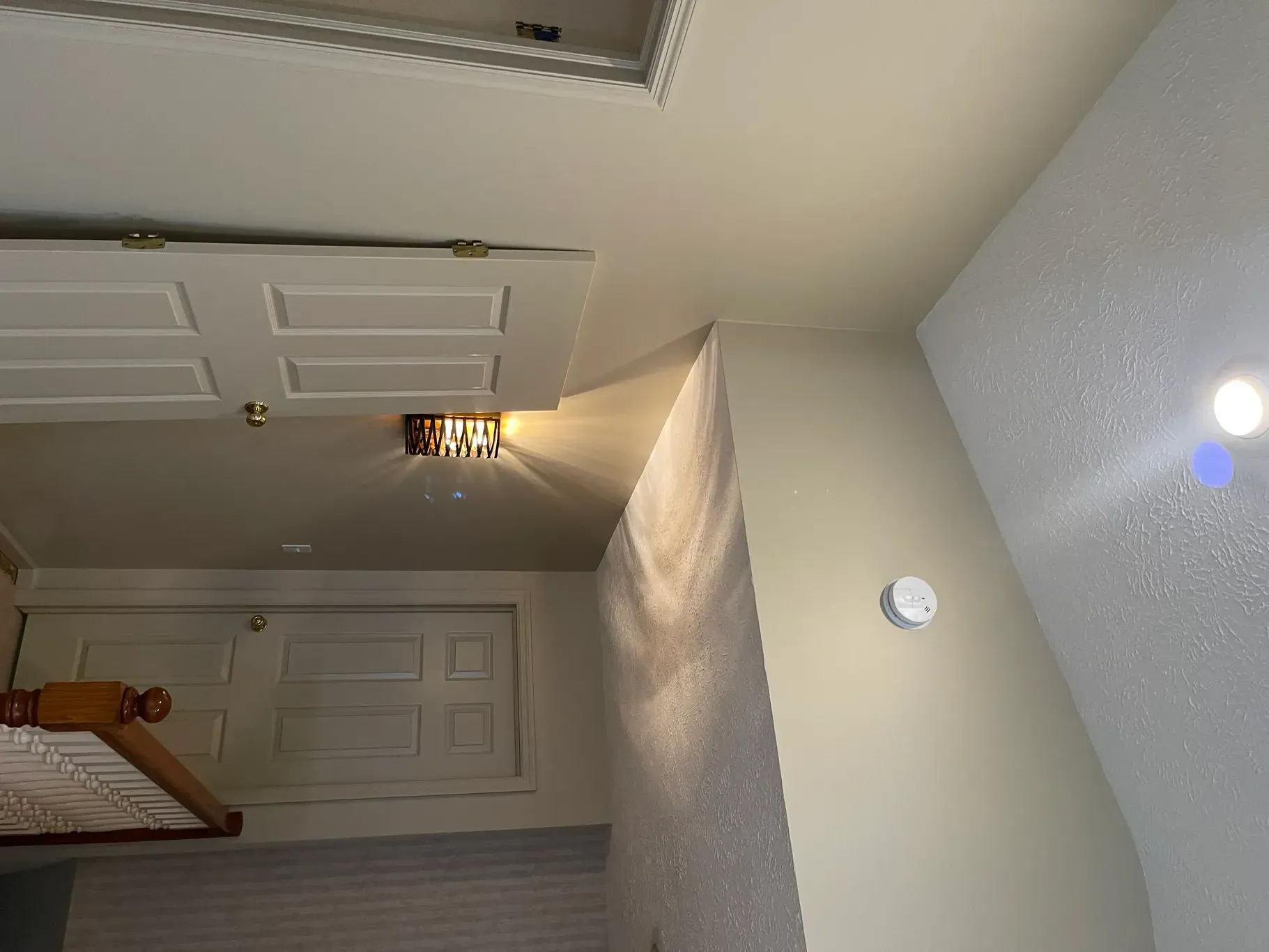 A bedroom with a bed and a ceiling light