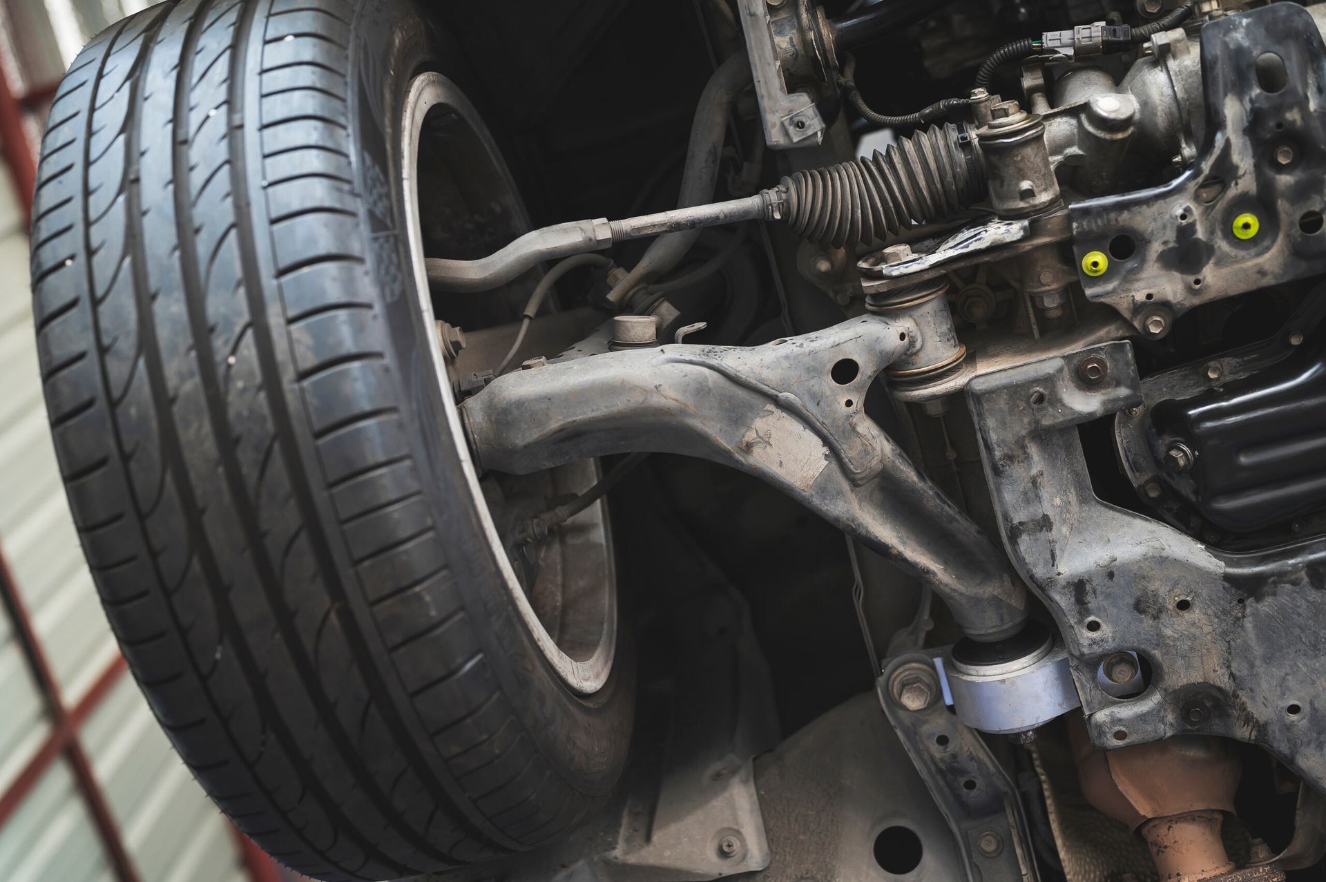 close-up of a vehicle's front wheel and suspension during tyre inspection on the Central Coast