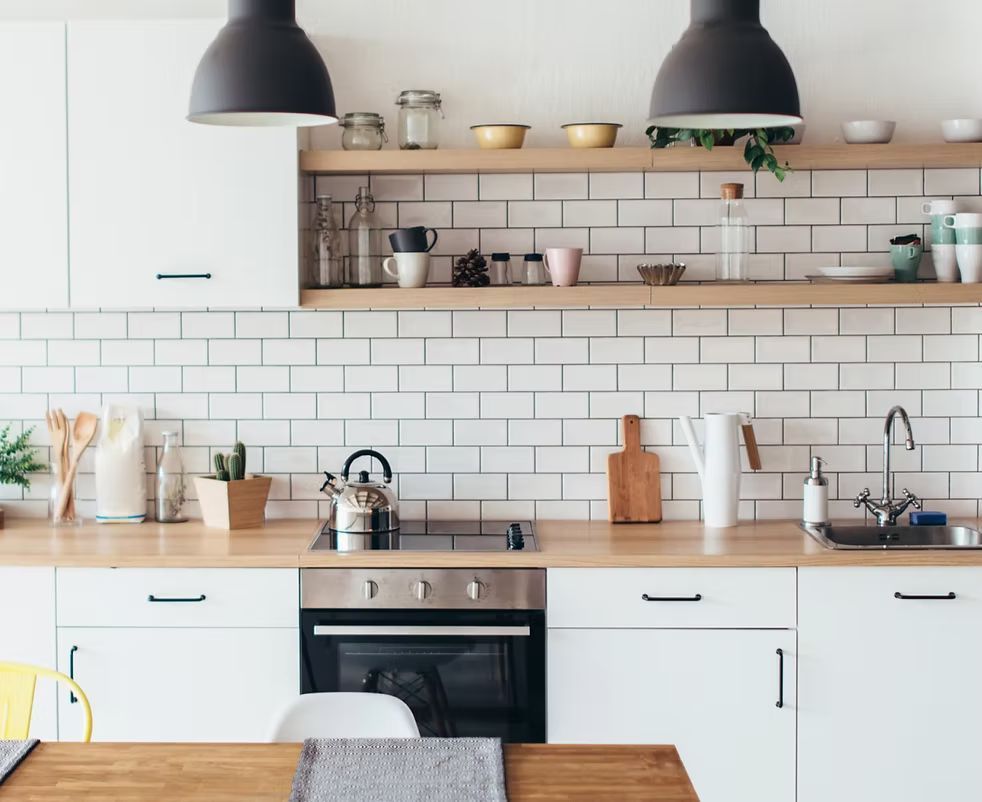 An apartment kitchen with builder grade frameless cabinets and quartz countertops