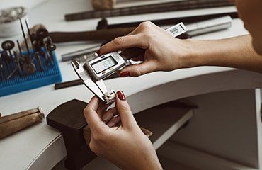 Engineer measuring a burn off wax master pattern to check shrinkage