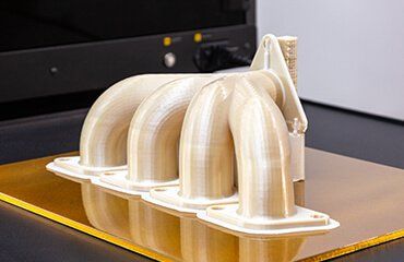 a ivory color 3d printed part by Ultem 1010 display on top of a table