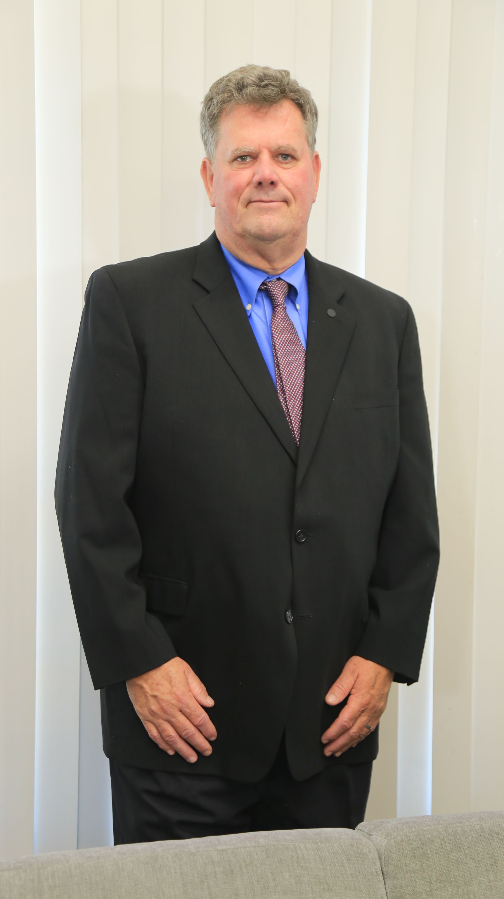 Woman in a neck brace and sling consults with a person holding a tablet on a couch.