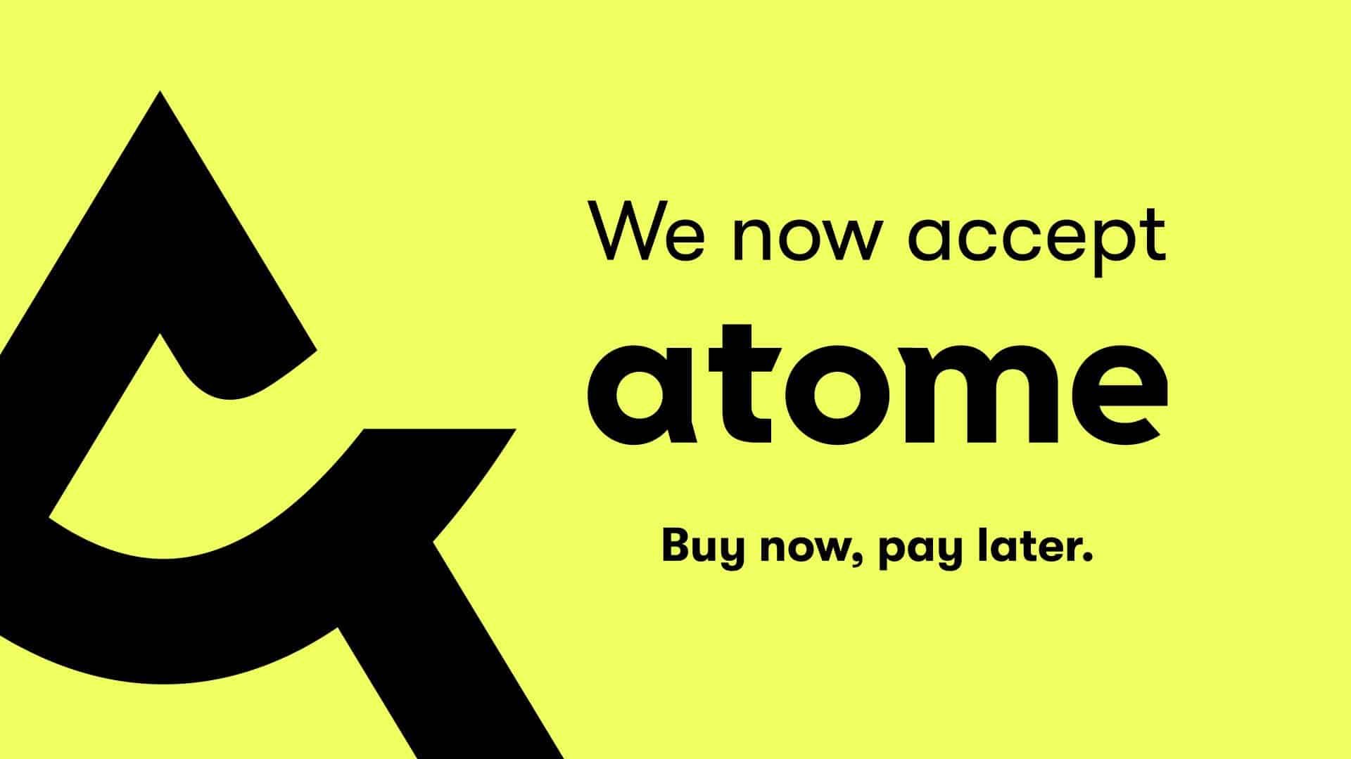 A yellow sign that says we now accept atome buy now pay later