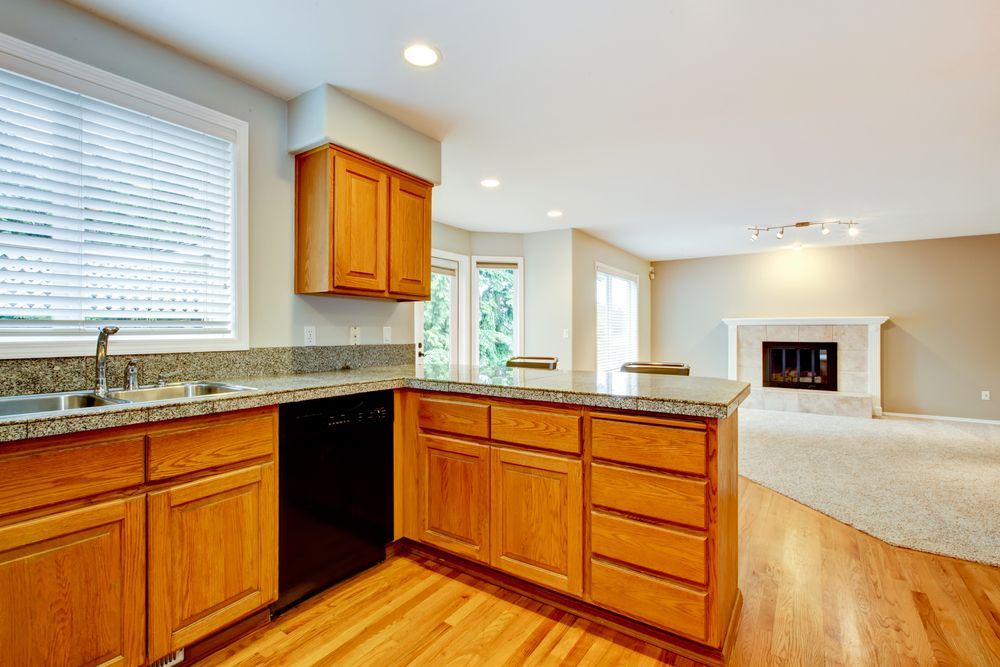 Kitchen With Wooden Cabinets, Granite Countertops, and Hardwood Floors — Morrison Cabinetry in Tin Can Bay, QLD