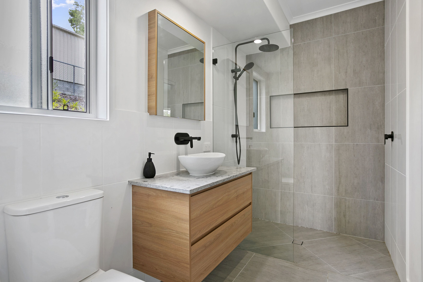 Modern bathroom with wooden vanity, white sink, and tiled shower. — Morrison Cabinetry in Cedar Pocket, QLD