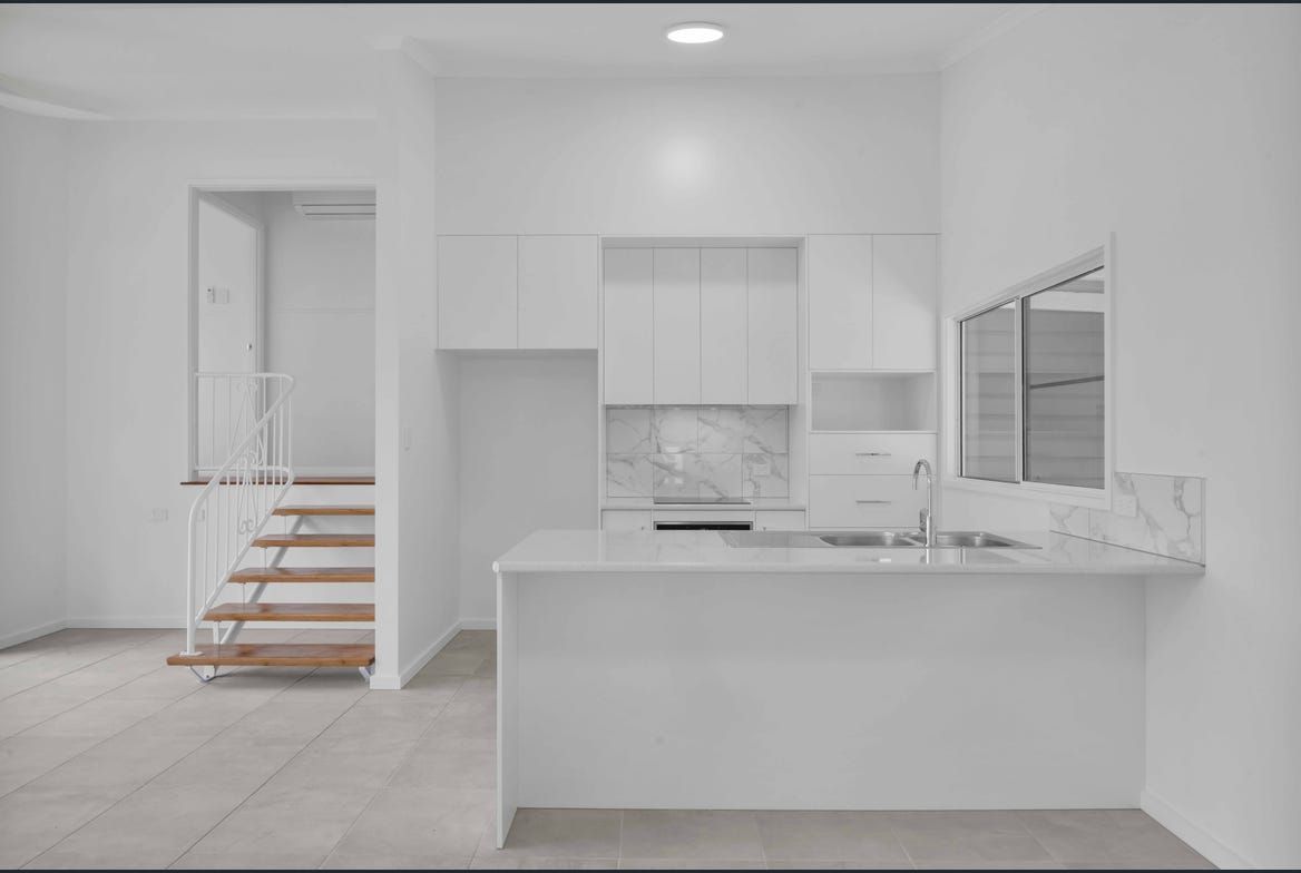 White kitchen with island seating and stainless steel appliances — Morrison Cabinetry in Cedar Pocket, QLD