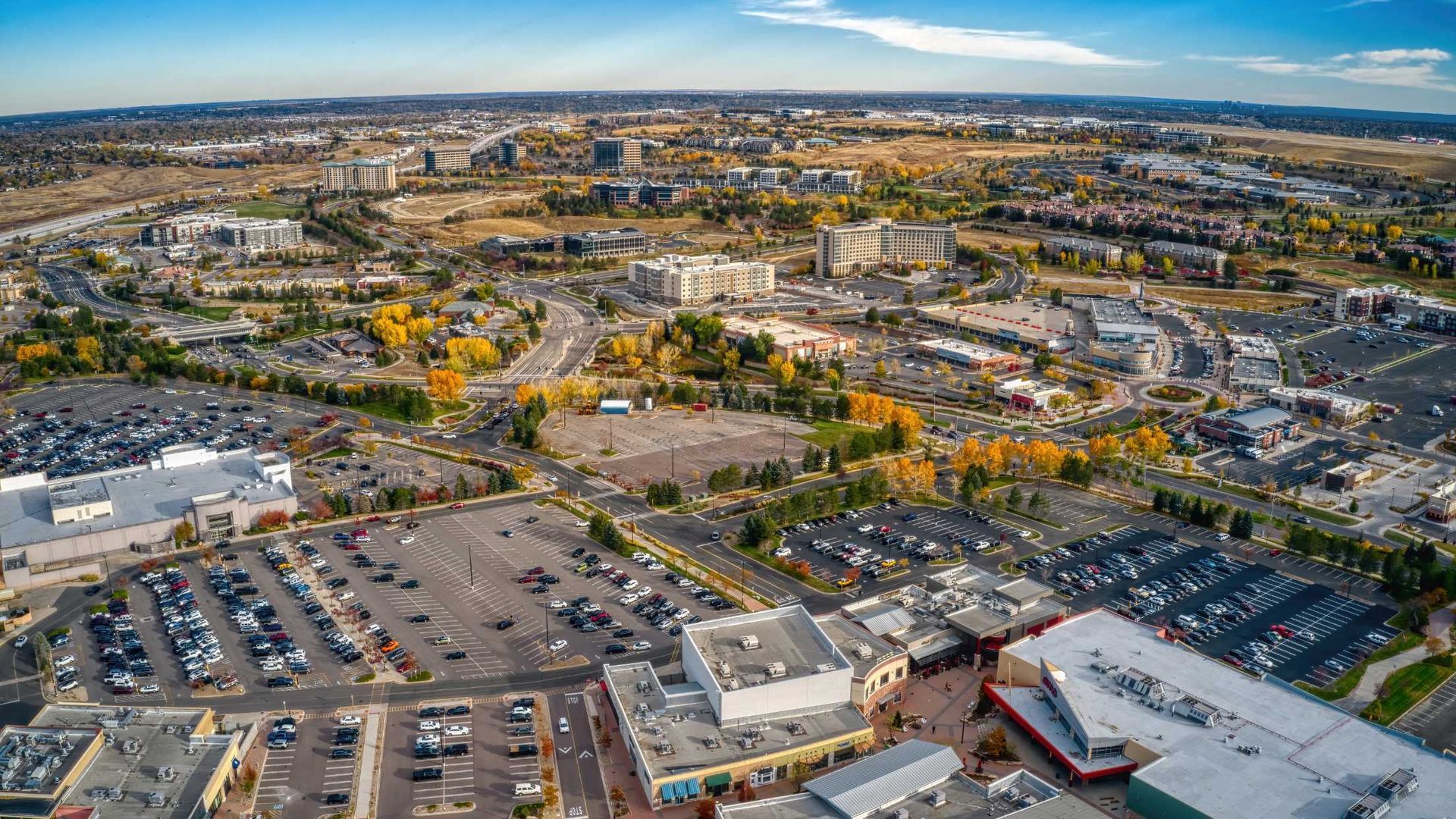 An aerial view of a city with lots of parking lots and buildings.