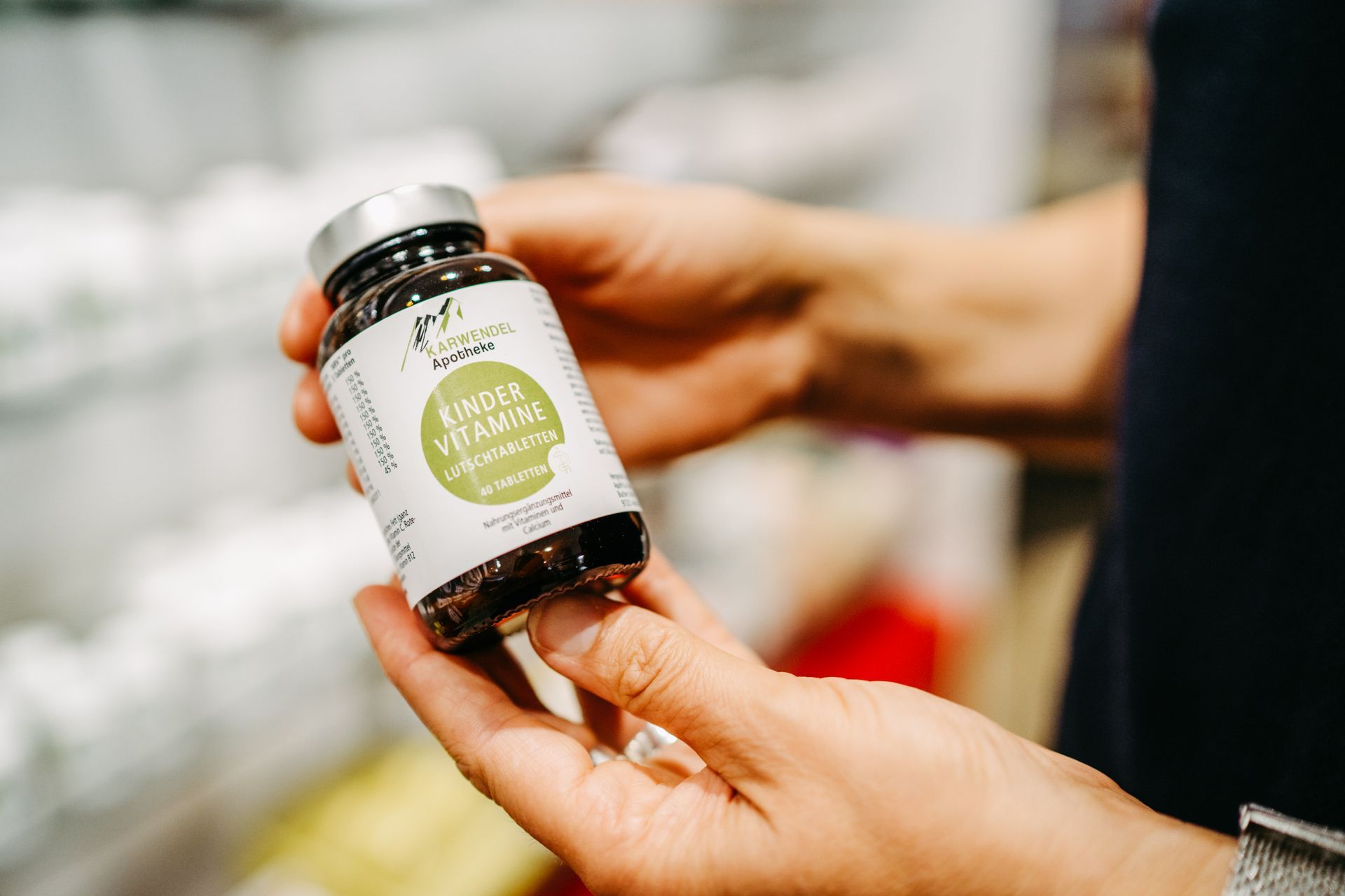 Eine Person hält eine Flasche Pillen in der Hand.