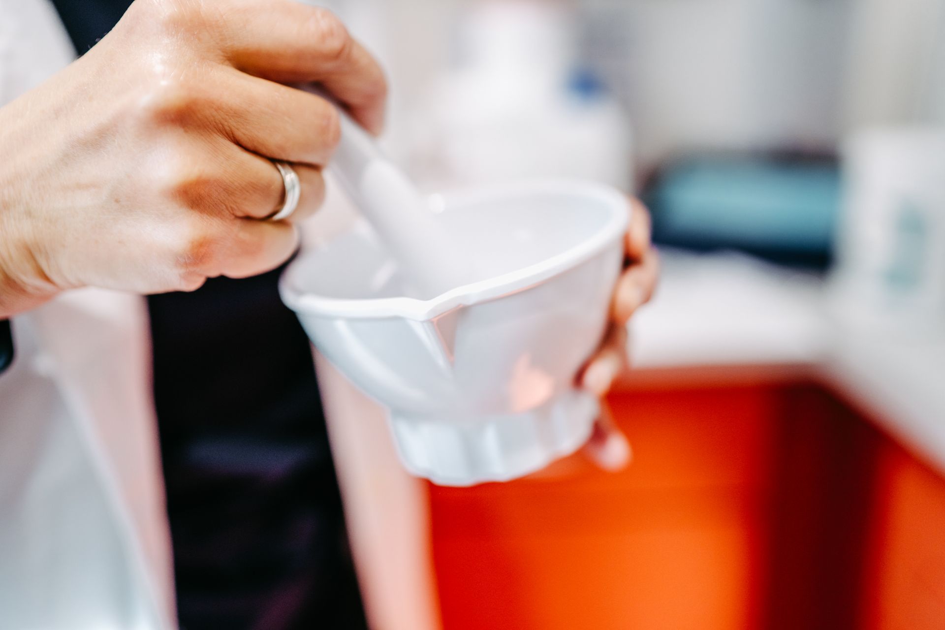 Eine Person mischt etwas in einem Mörser.