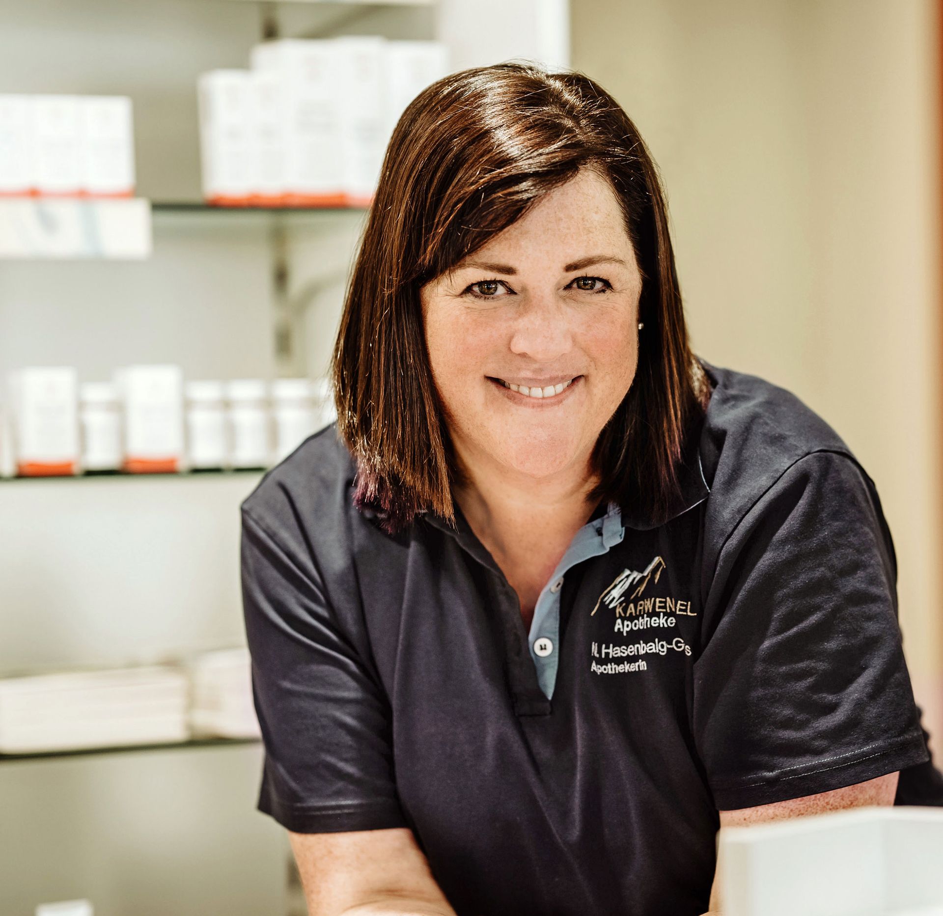 Eine Frau in einem schwarzen Hemd lächelt in die Kamera