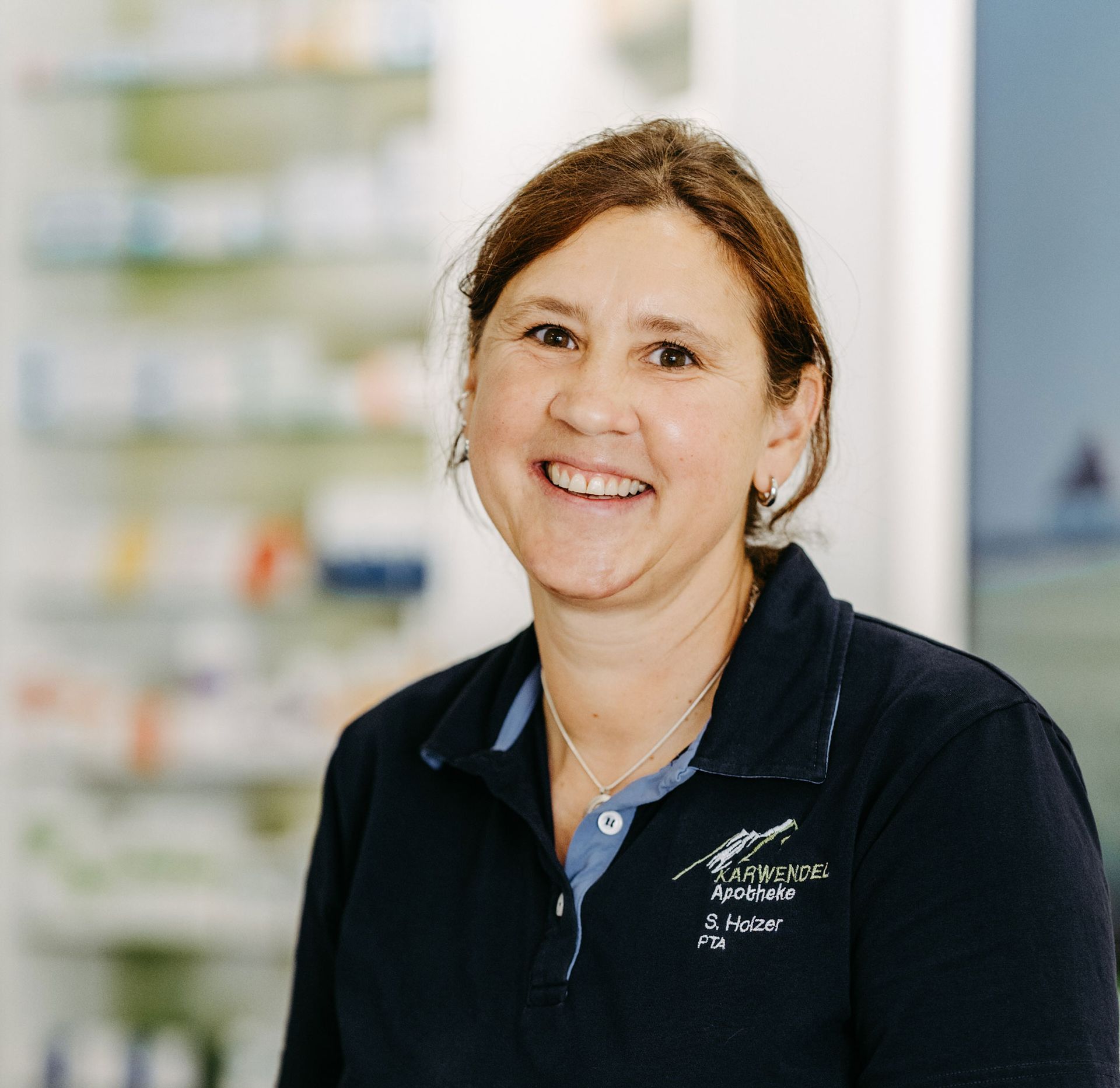 Eine Frau in einem schwarzen Hemd lächelt in die Kamera.