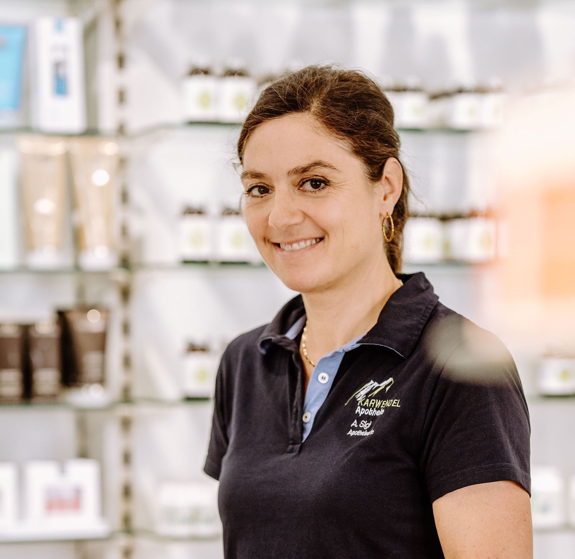 Eine Frau in einem schwarzen Poloshirt lächelt in einem Geschäft