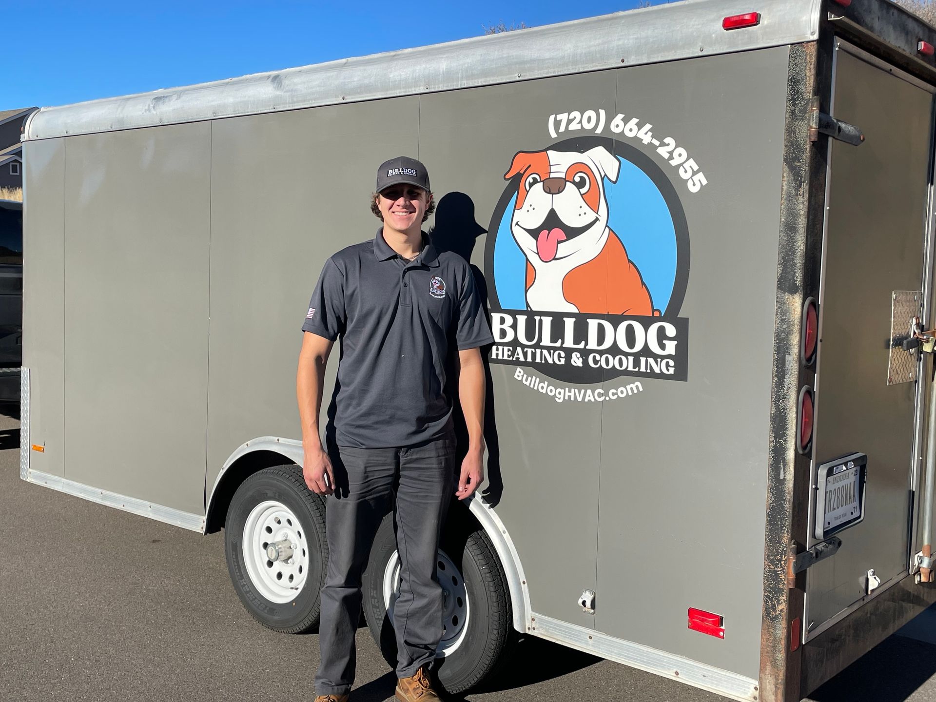 A man is standing in front of a bulldog trailer.