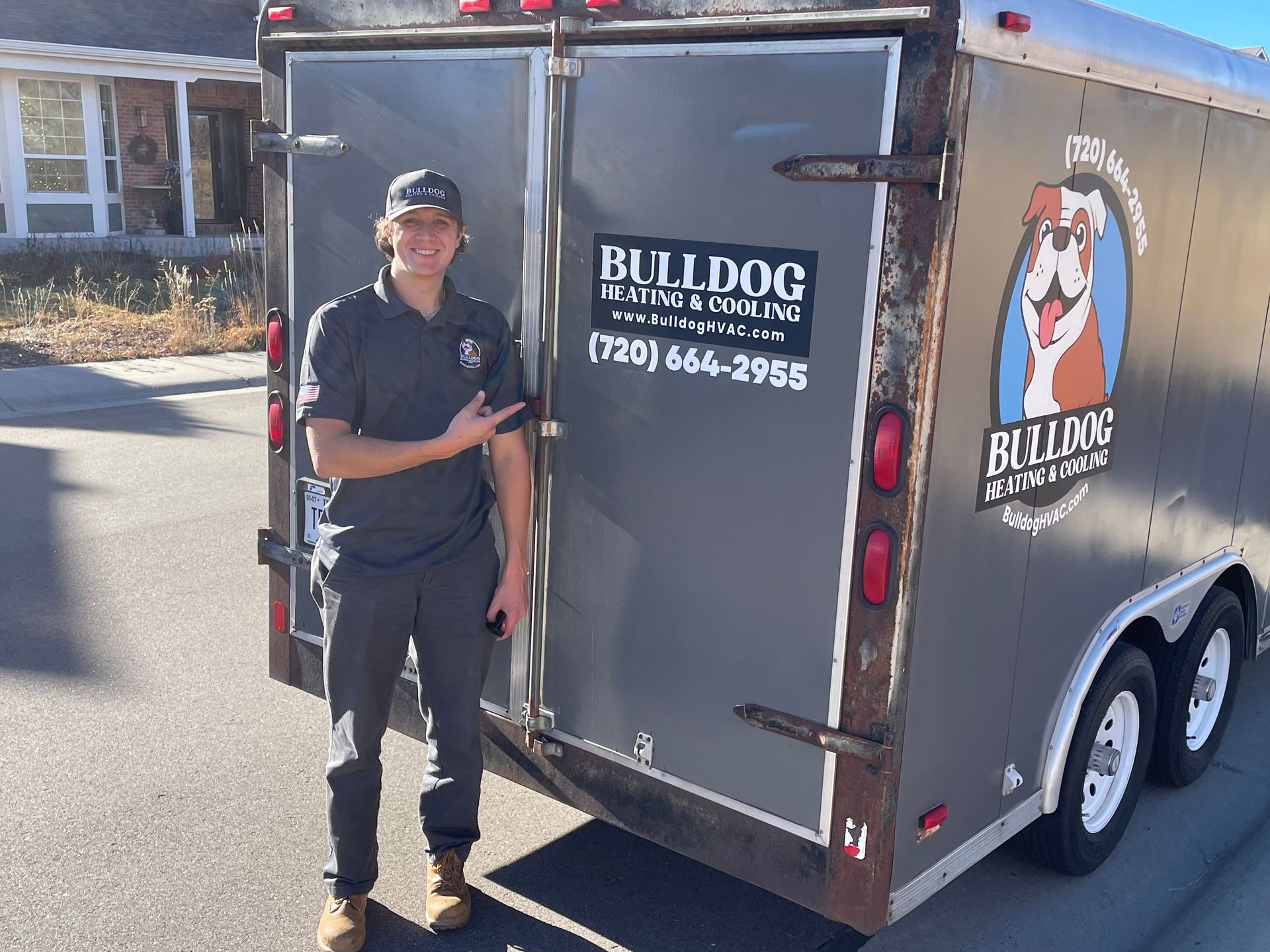 A man is standing in front of a bulldog trailer.