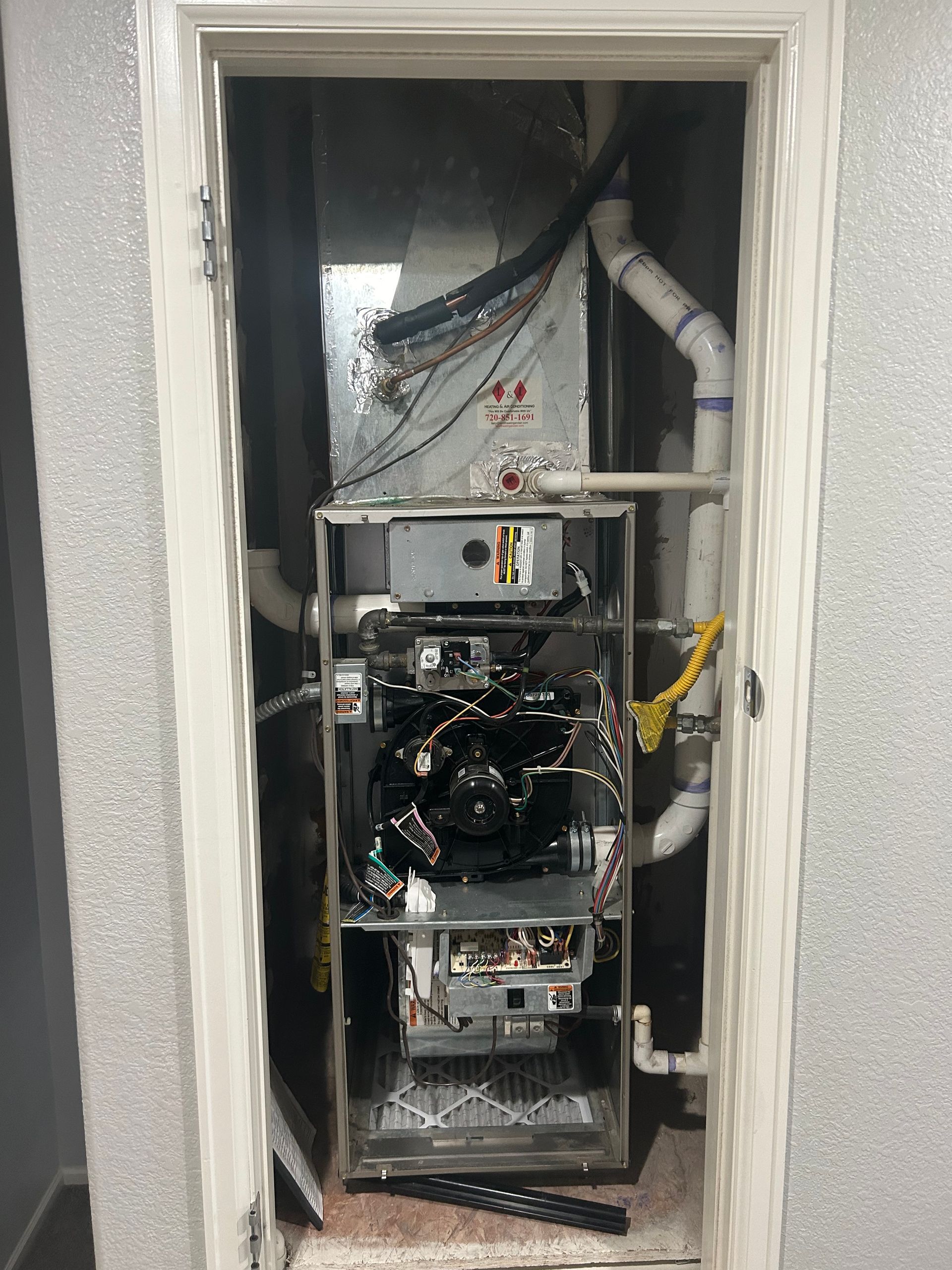 A broken air conditioner is sitting inside of a doorway.