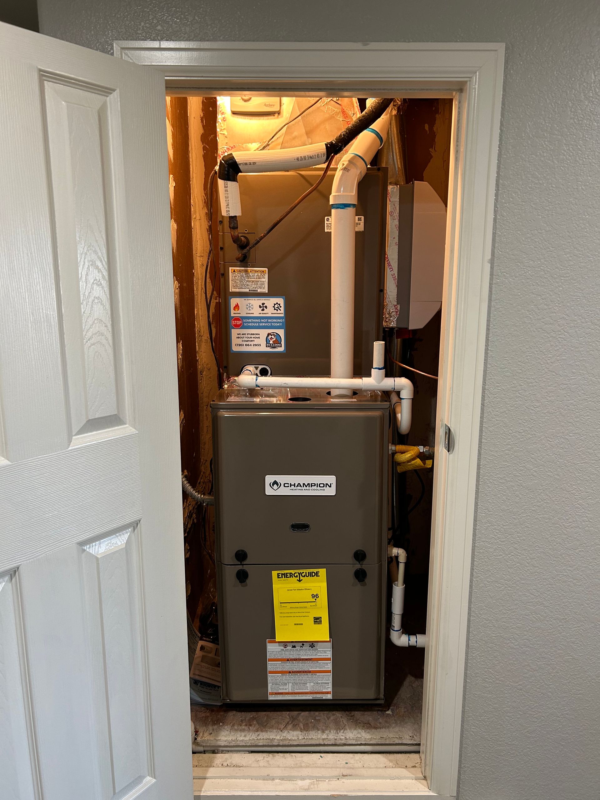 A furnace is sitting inside of a doorway in a room.