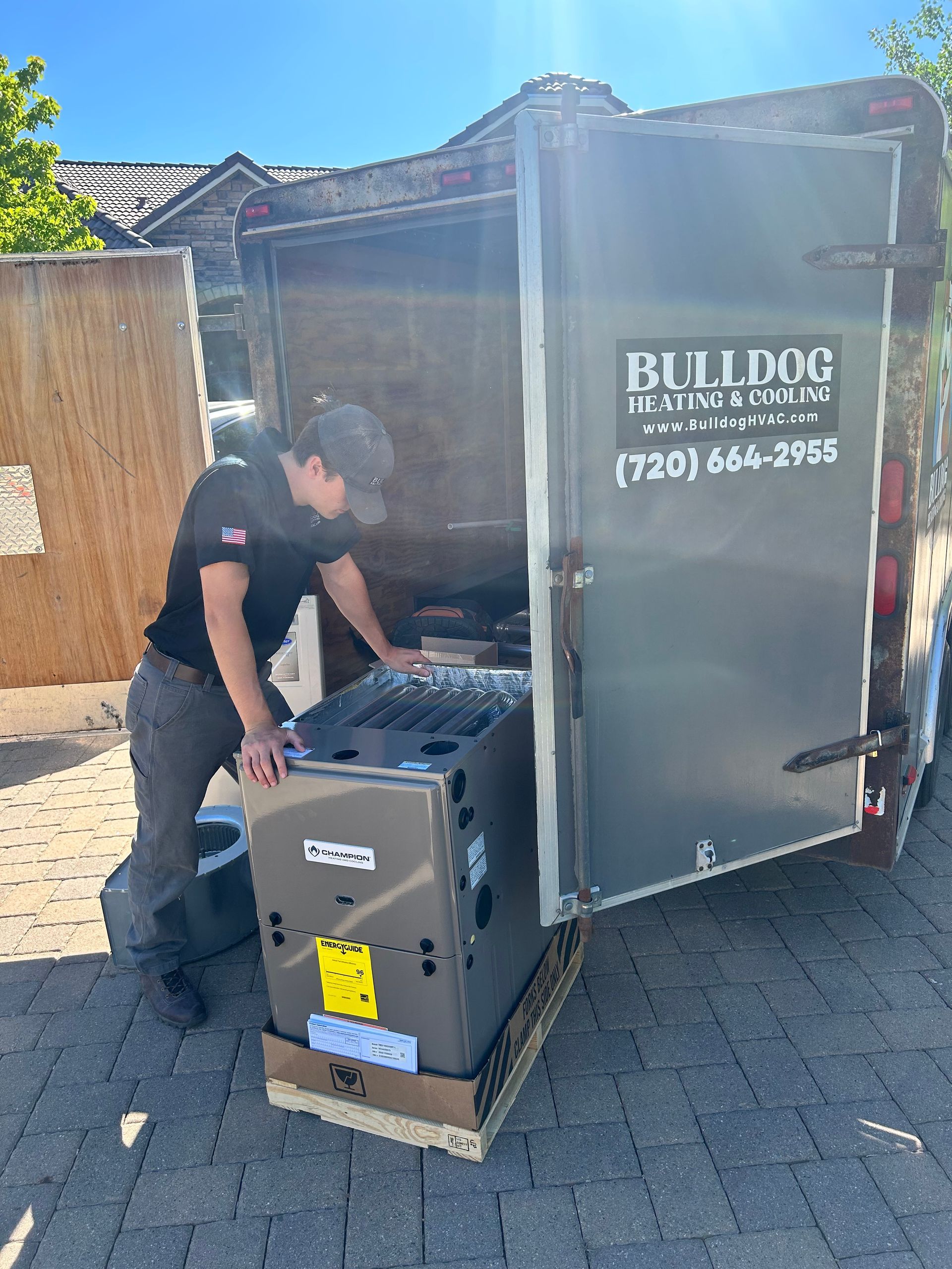 A man is loading a furnace into a trailer.