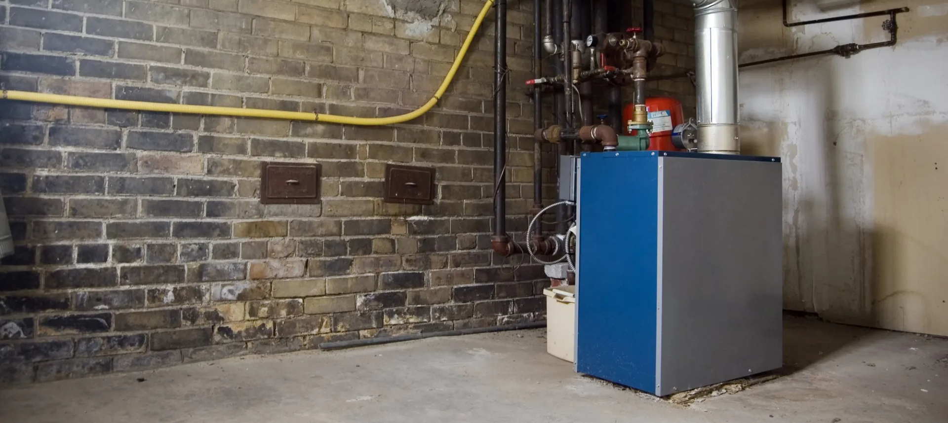 blue and grey furnace in empty basement