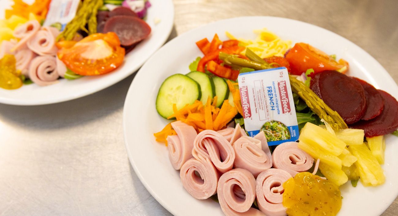 A white plate topped with a variety of vegetables and meat.