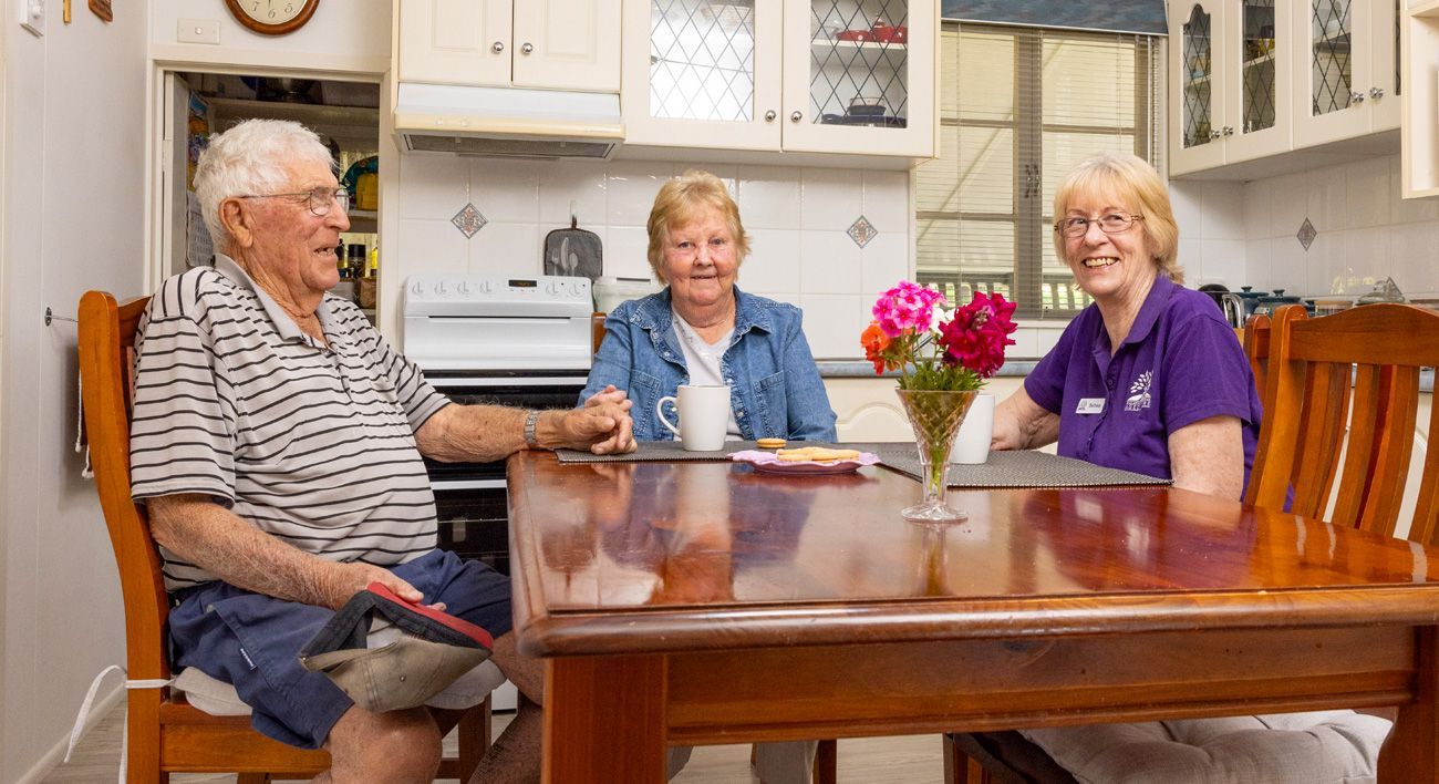 A group of people are sitting at a table in a kitchen.