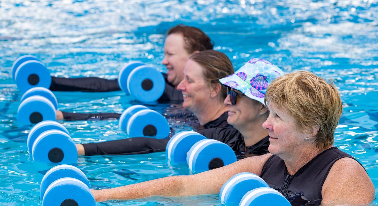 A group of women are doing aqua aerobics in a swimming pool.