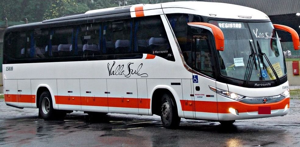 Onibus branco com faixa horizontal da cor laranja da ValleSul, estacionado