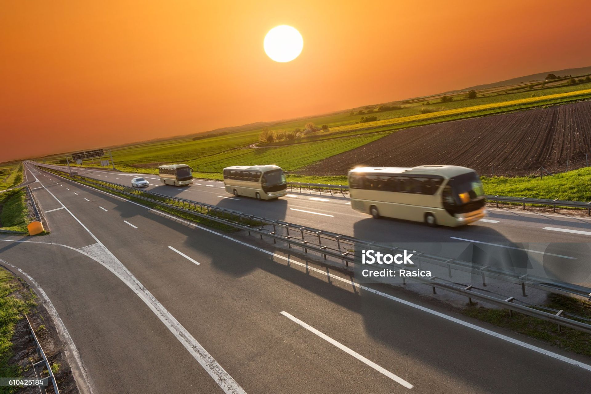 três ônibus em movimento em uma estrada