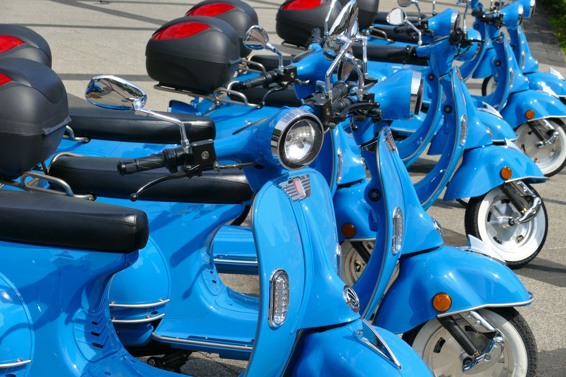 Een rij blauwe scooters. Deelscooters kunnen een oplossing zijn in de grondstoffentransitie.