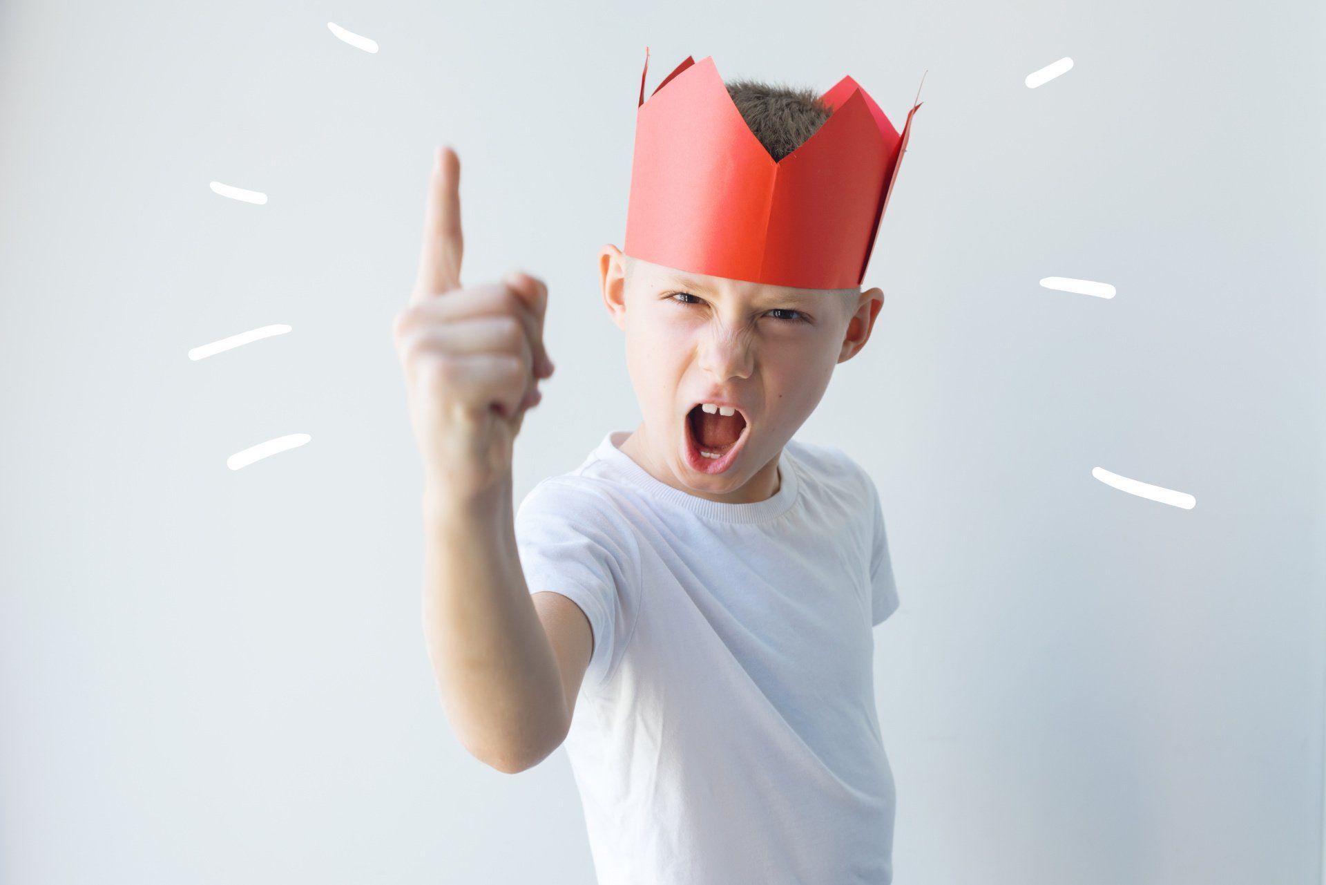 Jongen met rode papieren kroon heft schreeuwend een vinger op.