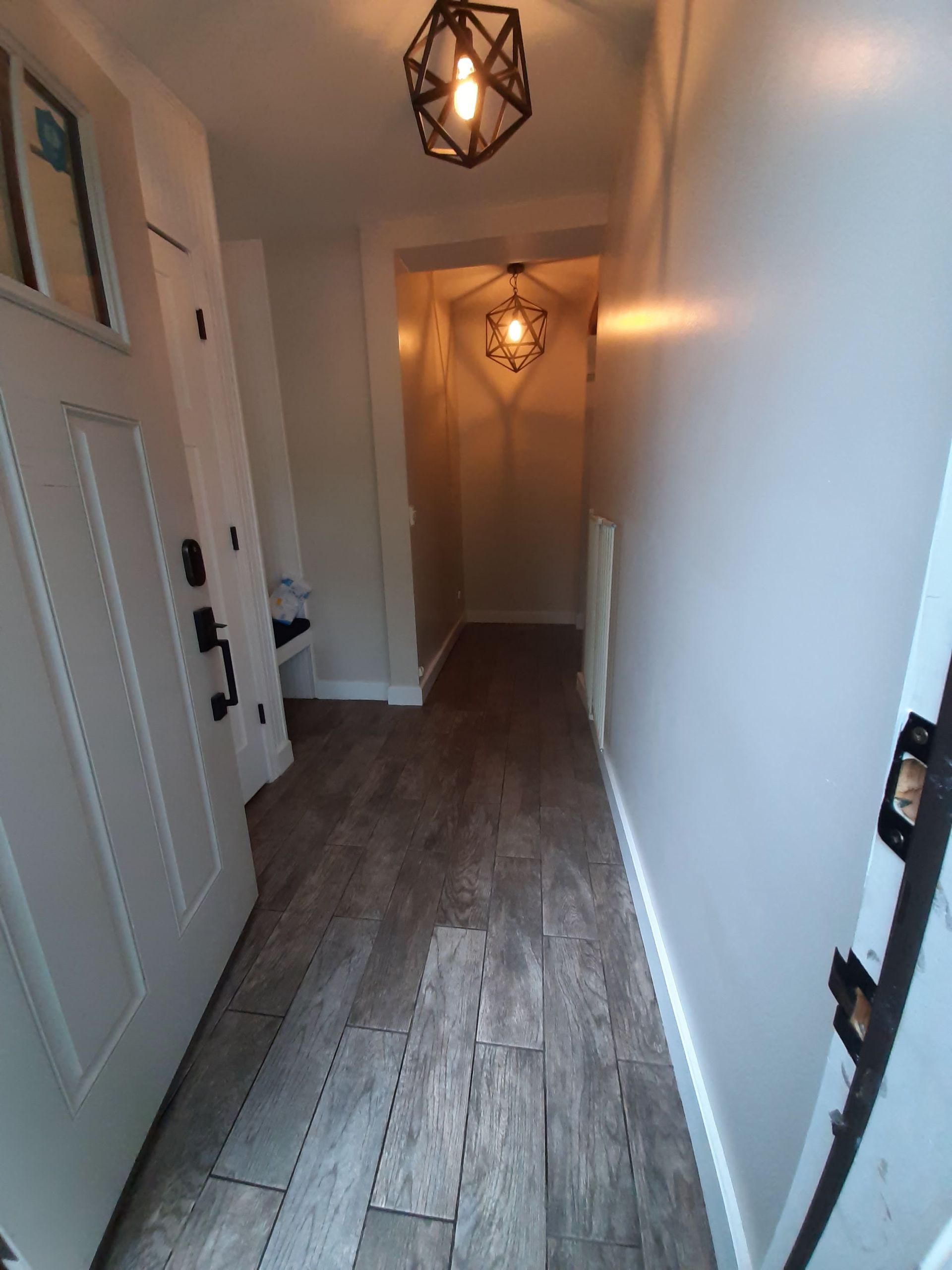 A hallway with a door and a light on the ceiling