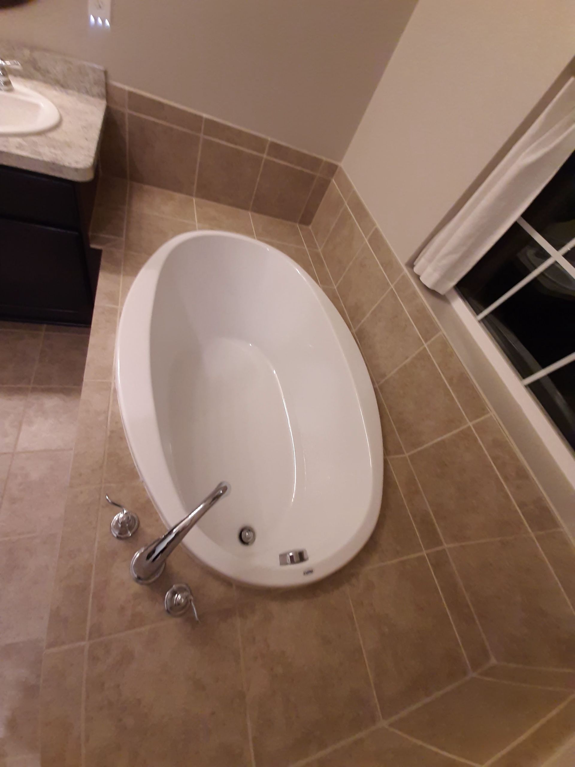 A bathtub in a bathroom next to a window