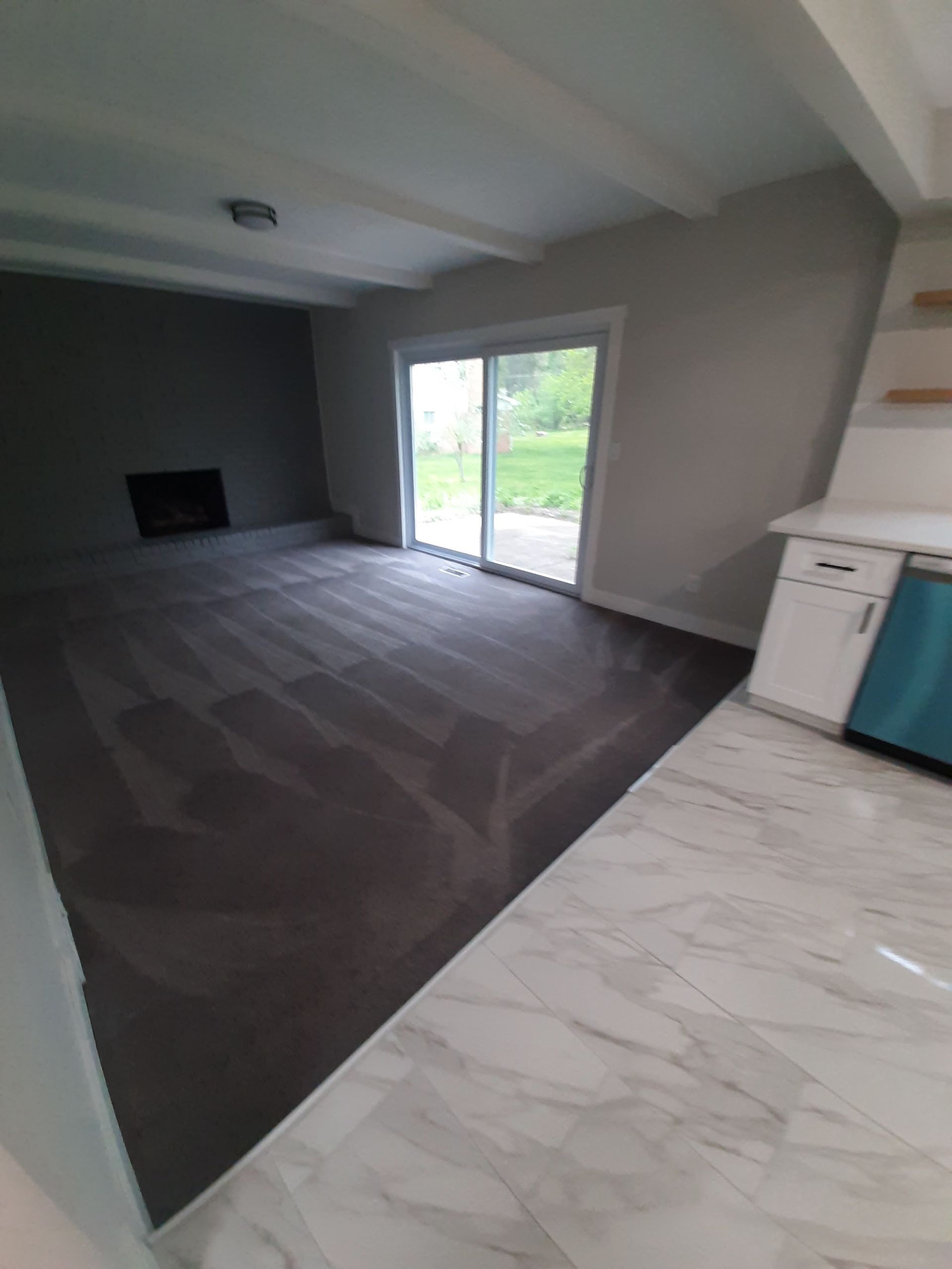 A living room with a fireplace and a sliding glass door.