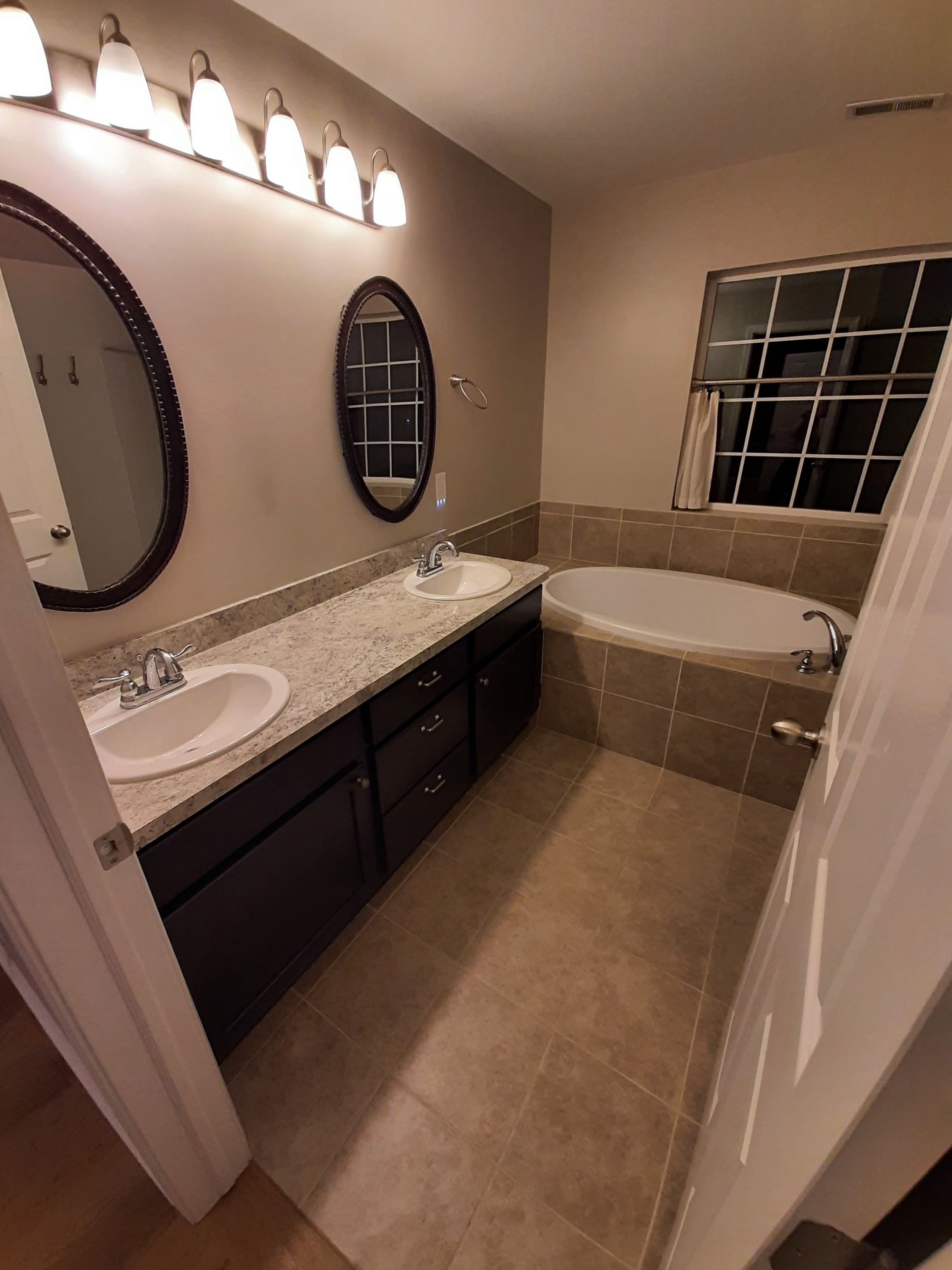 A bathroom with two sinks and a tub