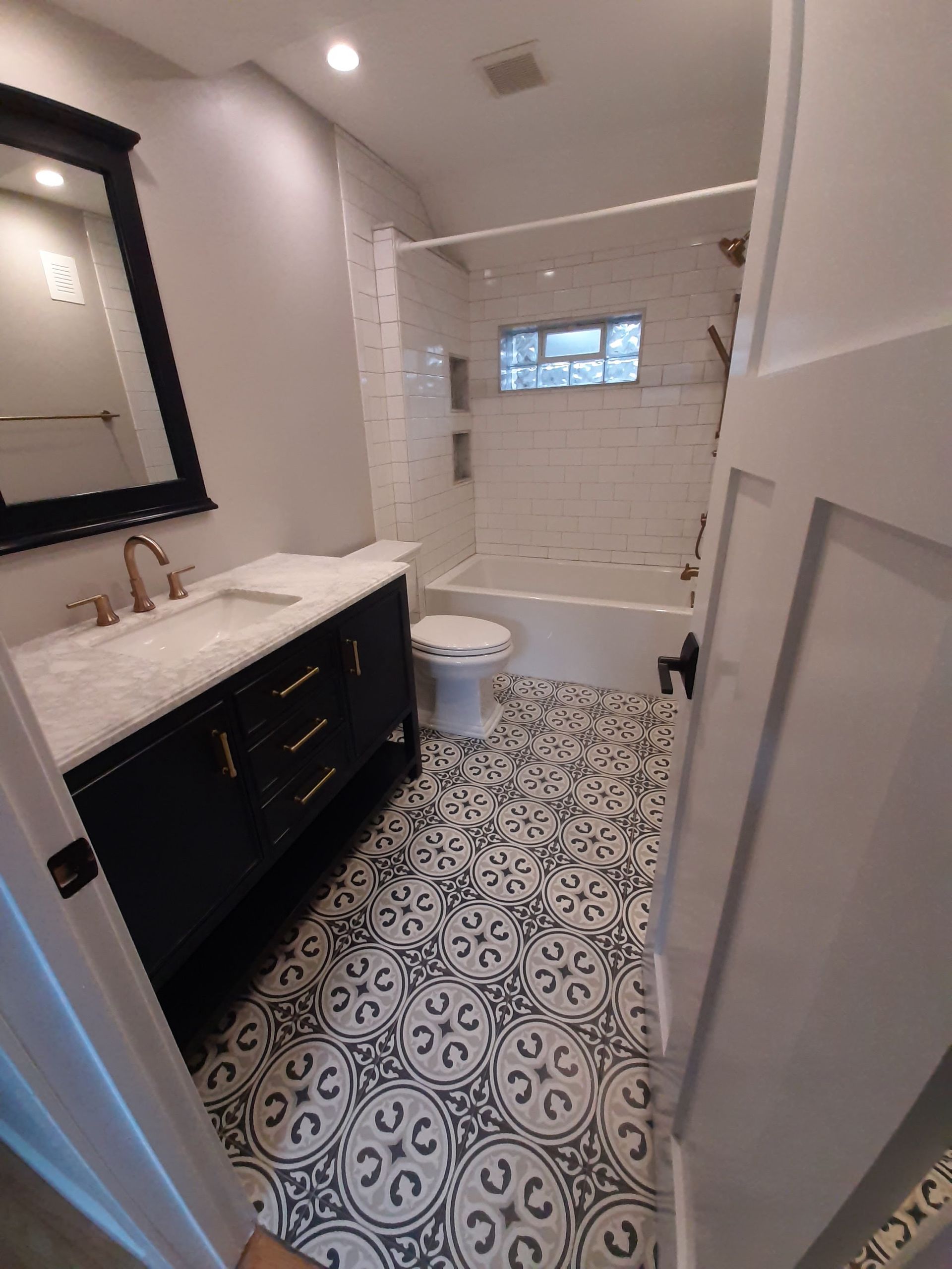 A bathroom with a sink , toilet , bathtub and mirror