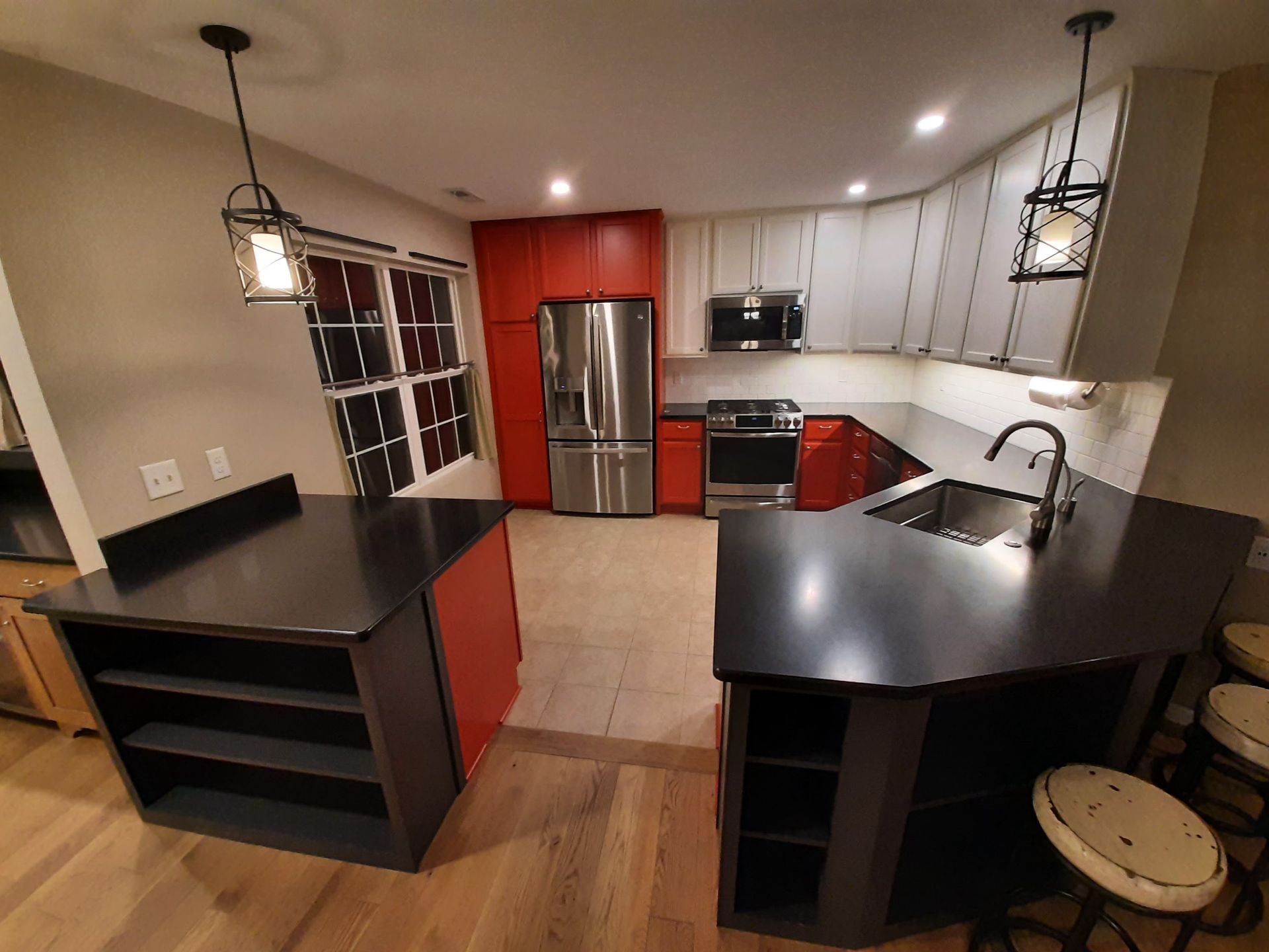 A kitchen with stainless steel appliances and red cabinets