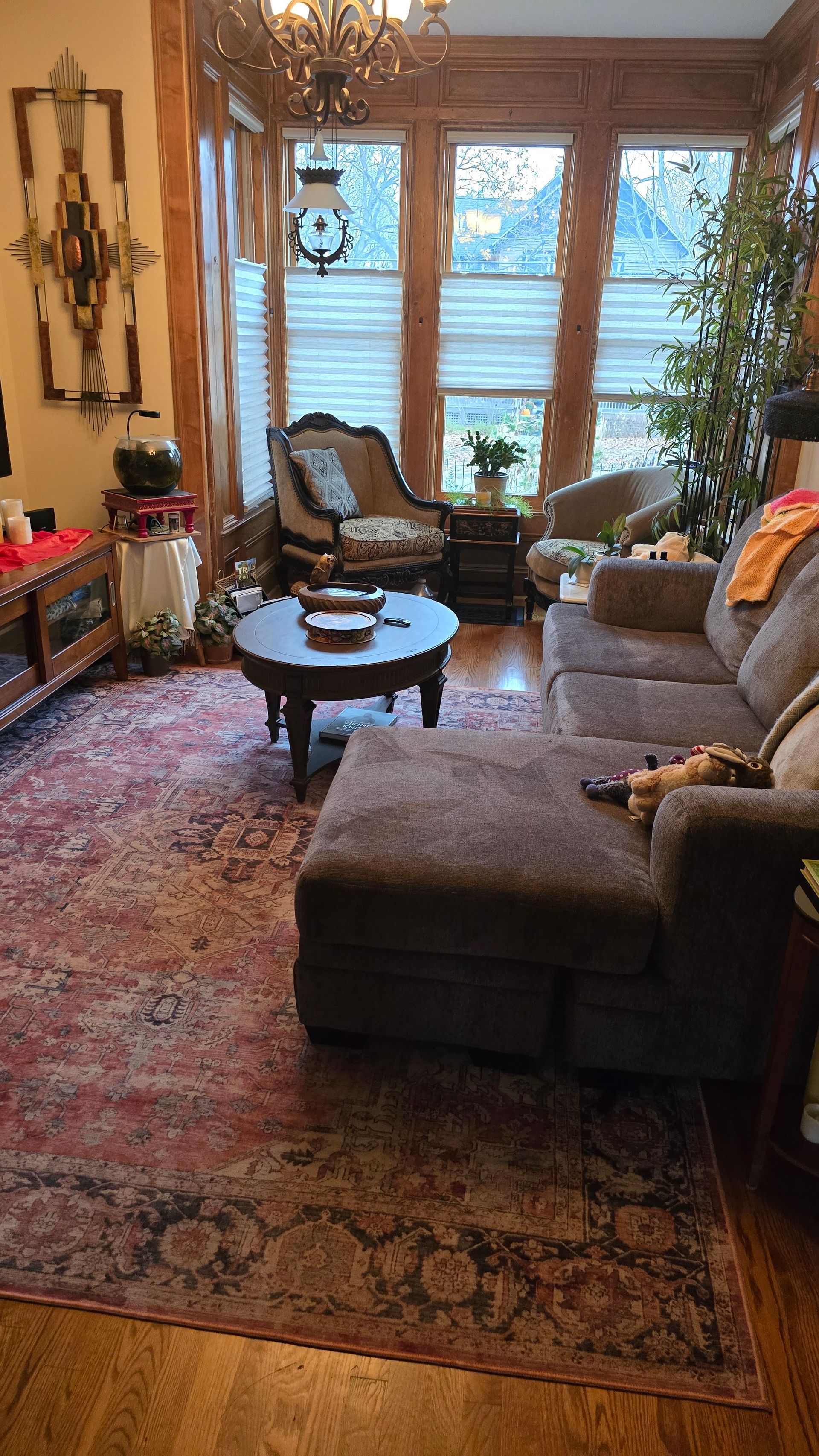 A living room with a couch , chairs , coffee table and rug.